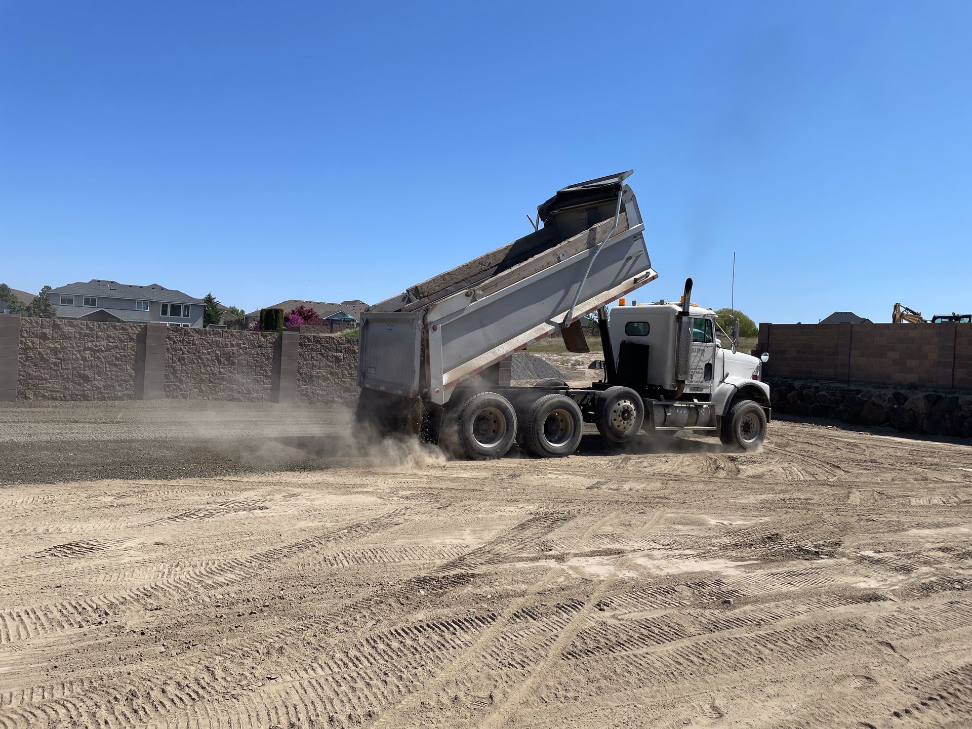 Image of a dump truck filling in gravel.