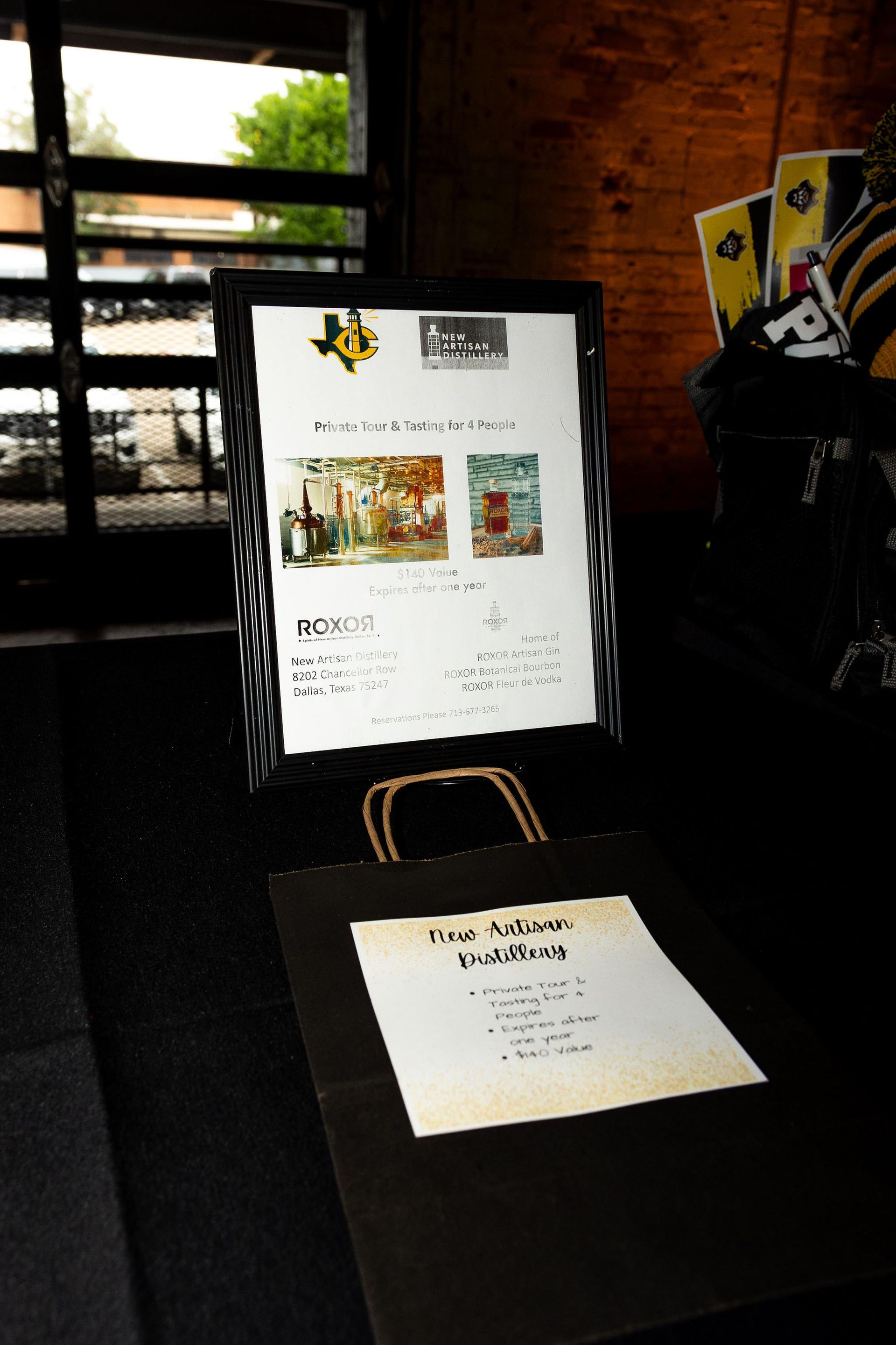 Menu on a digital screen, bag, and printed menu on a table. Texas logo on the screen.