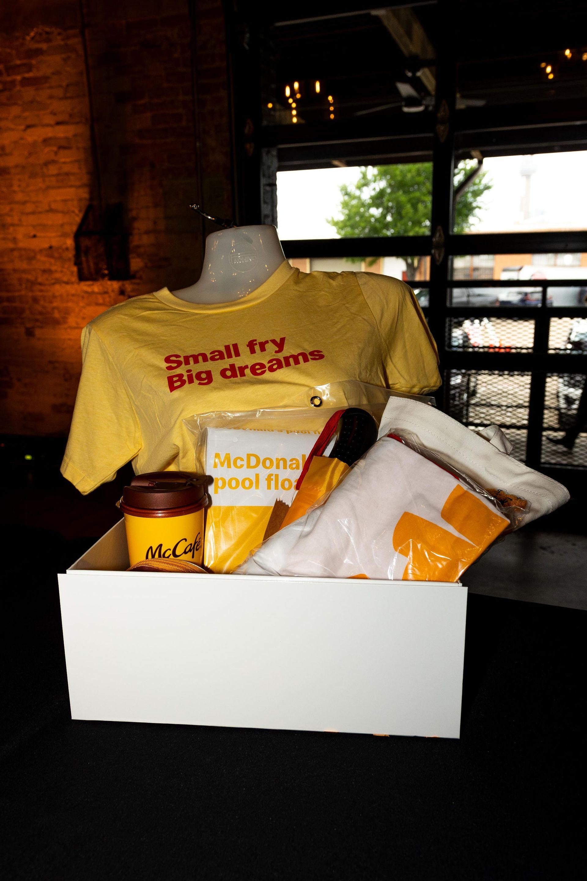 Box with McDonald's merchandise: yellow shirt, socks, dipping sauce, and 