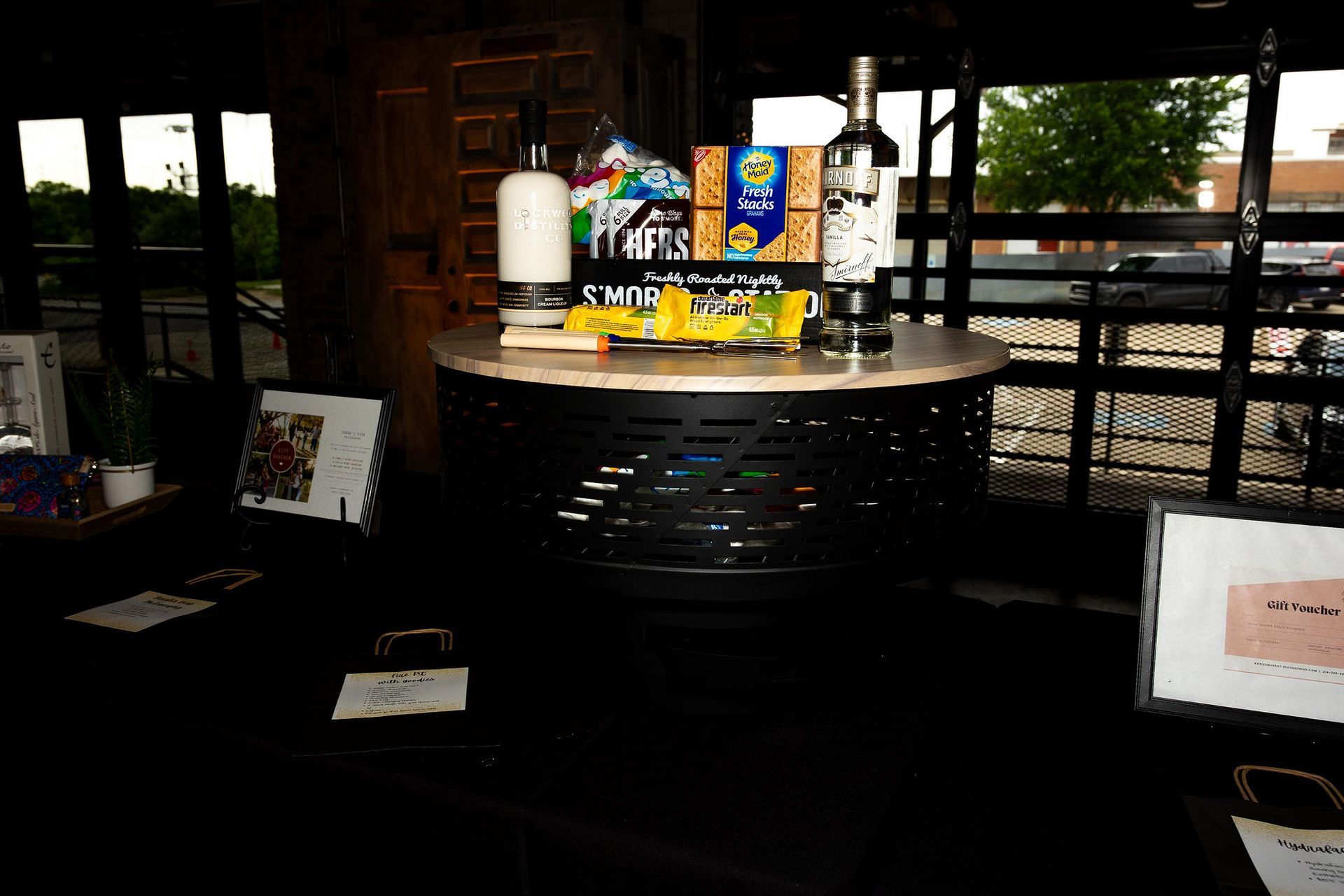 Round table with snacks and wine, in front of an outdoor area.