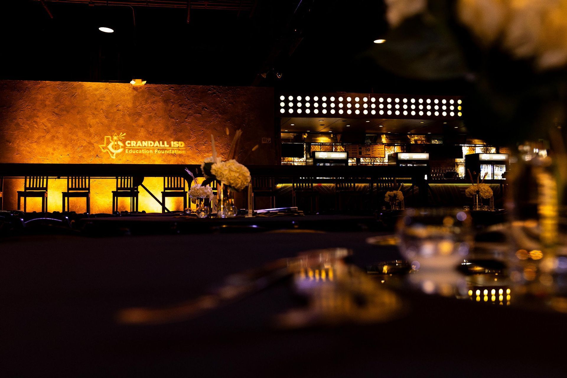 Restaurant interior with a dark ambiance. A bar is visible.