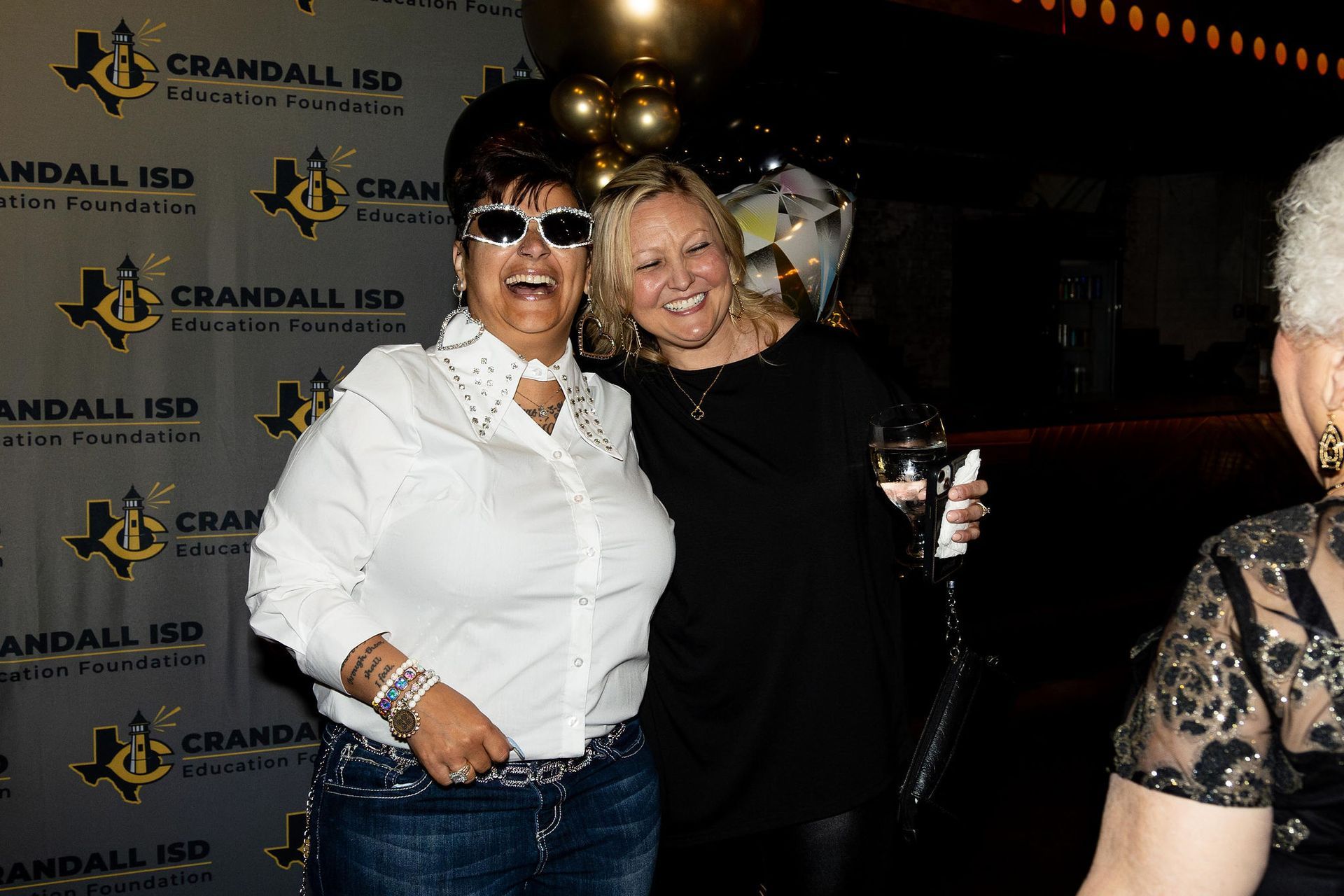 Two smiling women pose at an event with a 