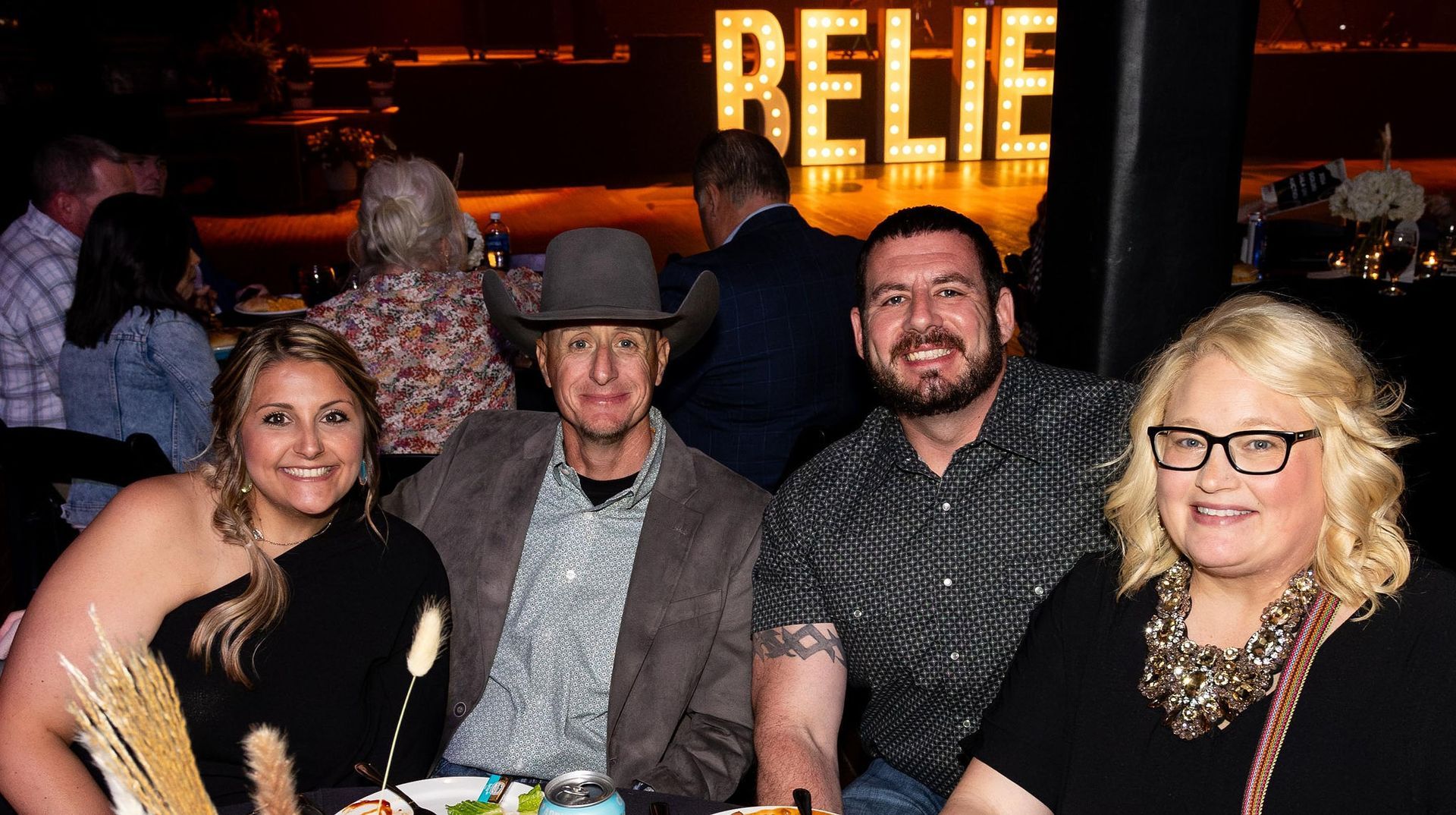 People seated at a table in a dimly lit bar. The word 