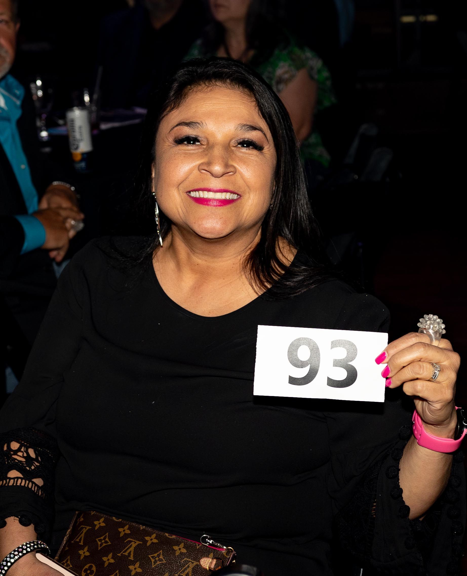 Woman smiling, holding a sign with 
