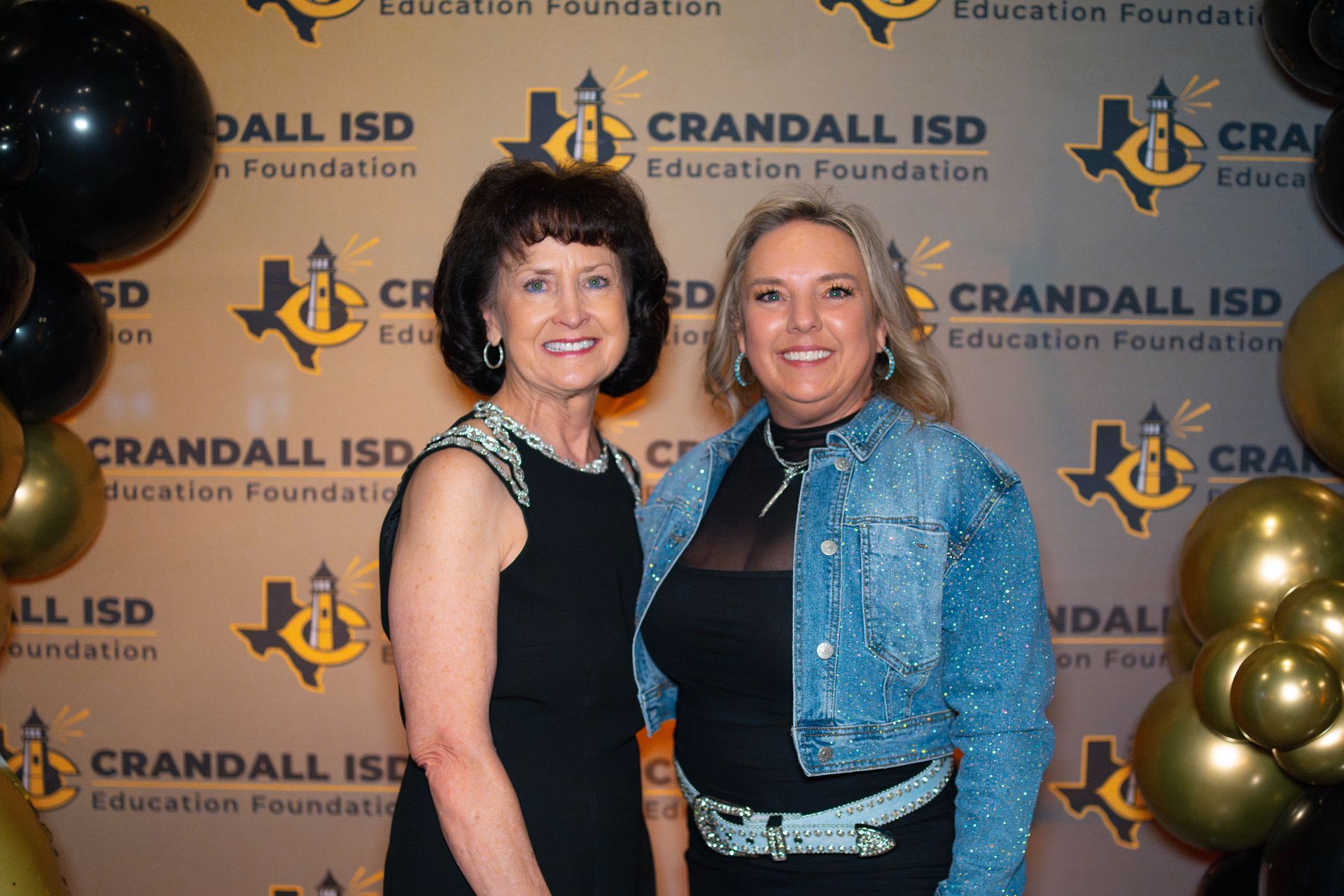 Two women posing in front of a 