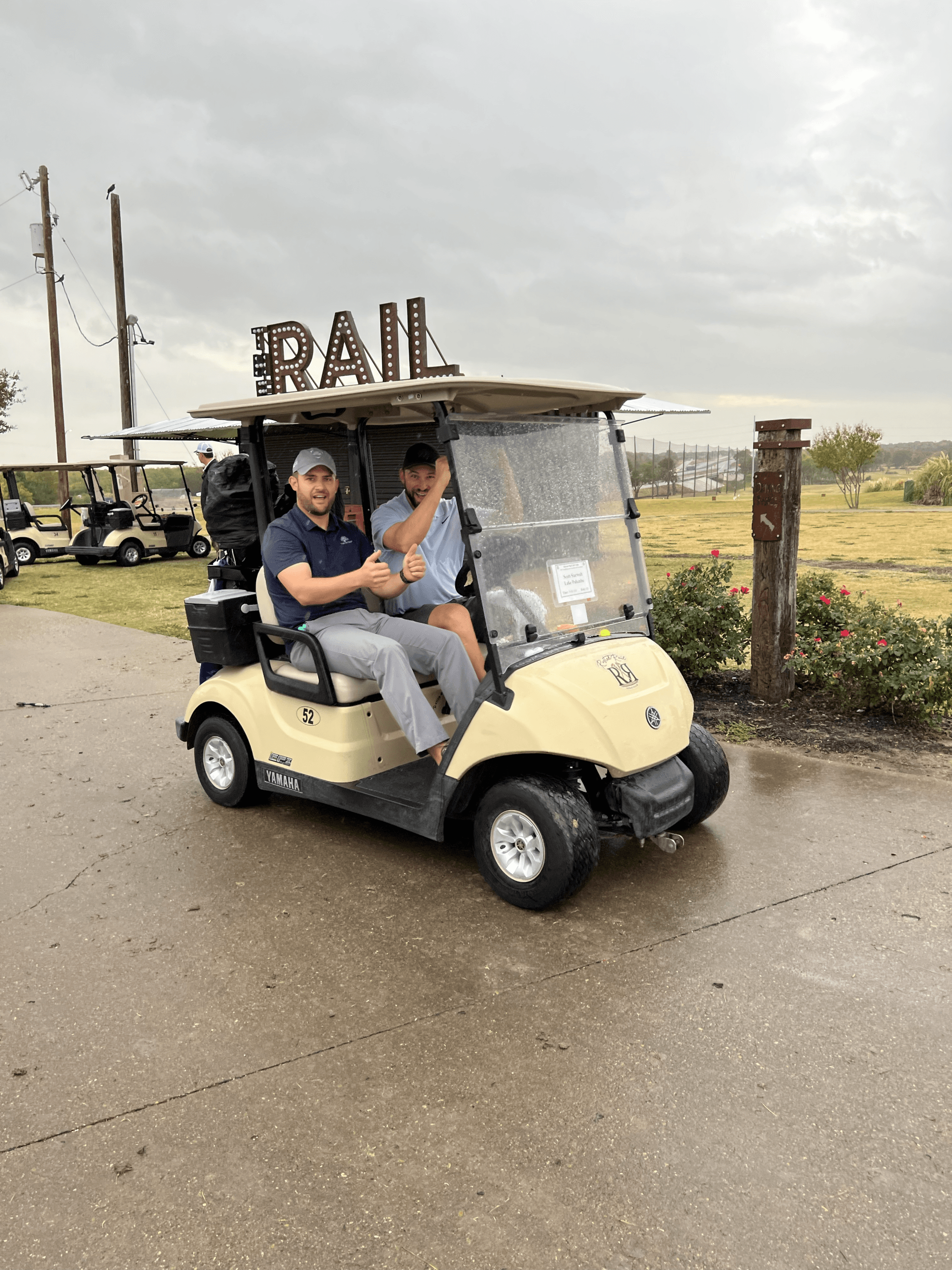 Two men in a beige golf cart, 