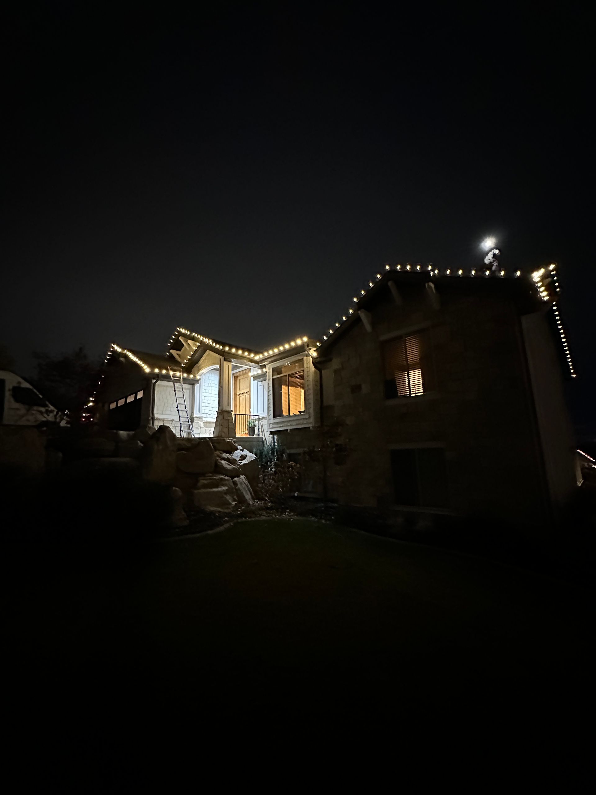 A house is lit up with christmas lights at night