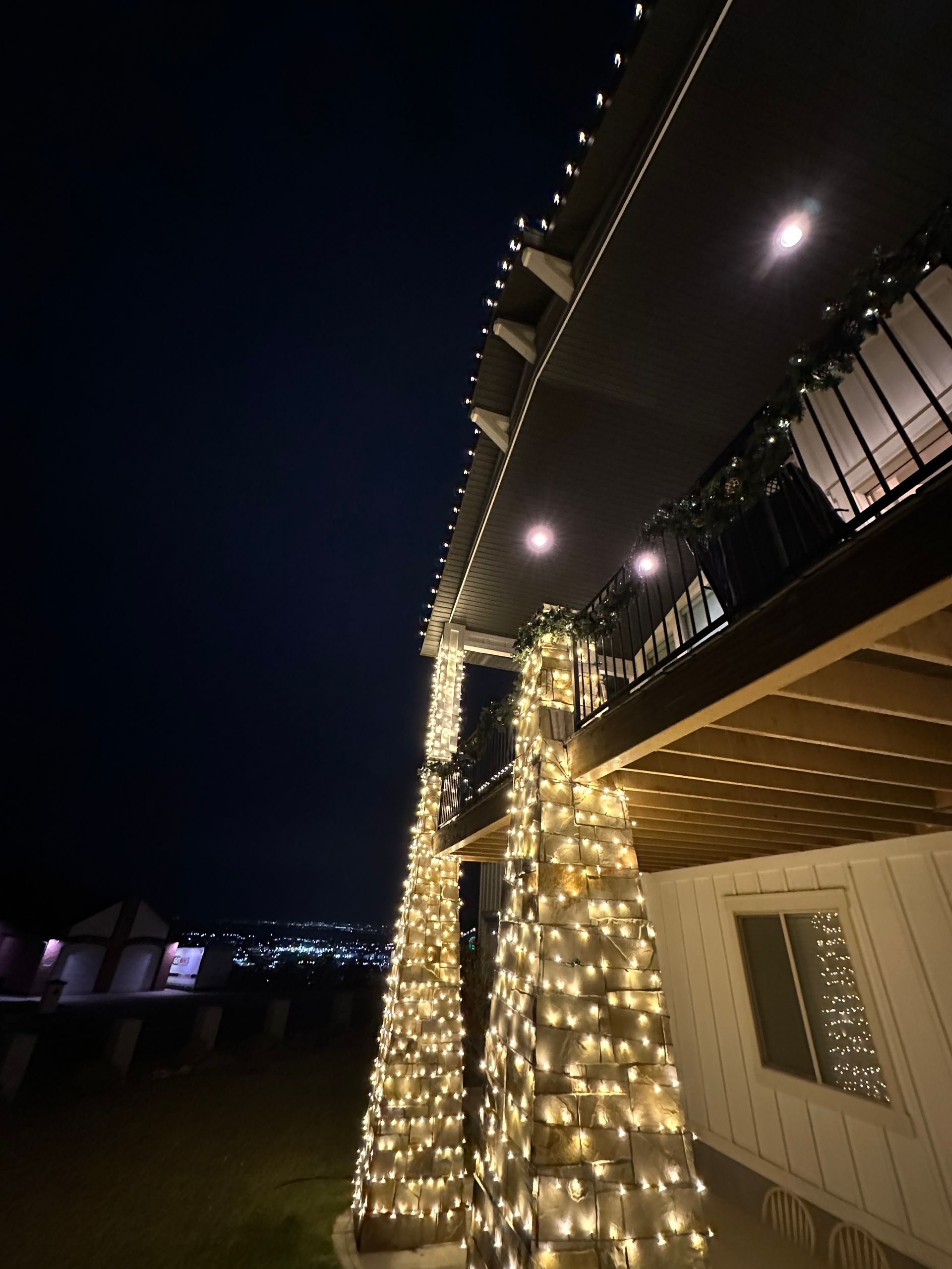 A house is decorated with christmas lights and pumpkins at night.