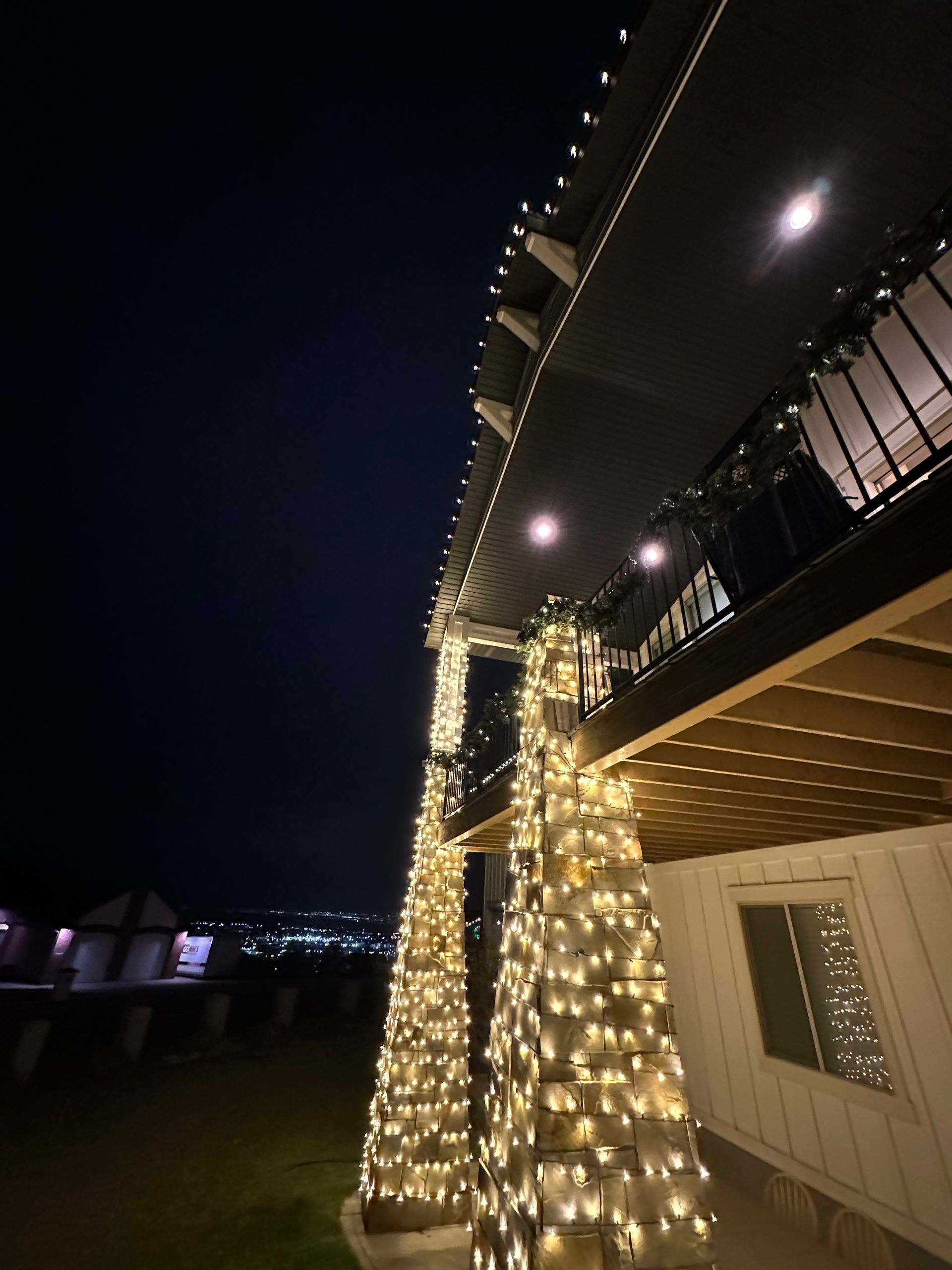 A house is decorated with christmas lights and pumpkins at night.
