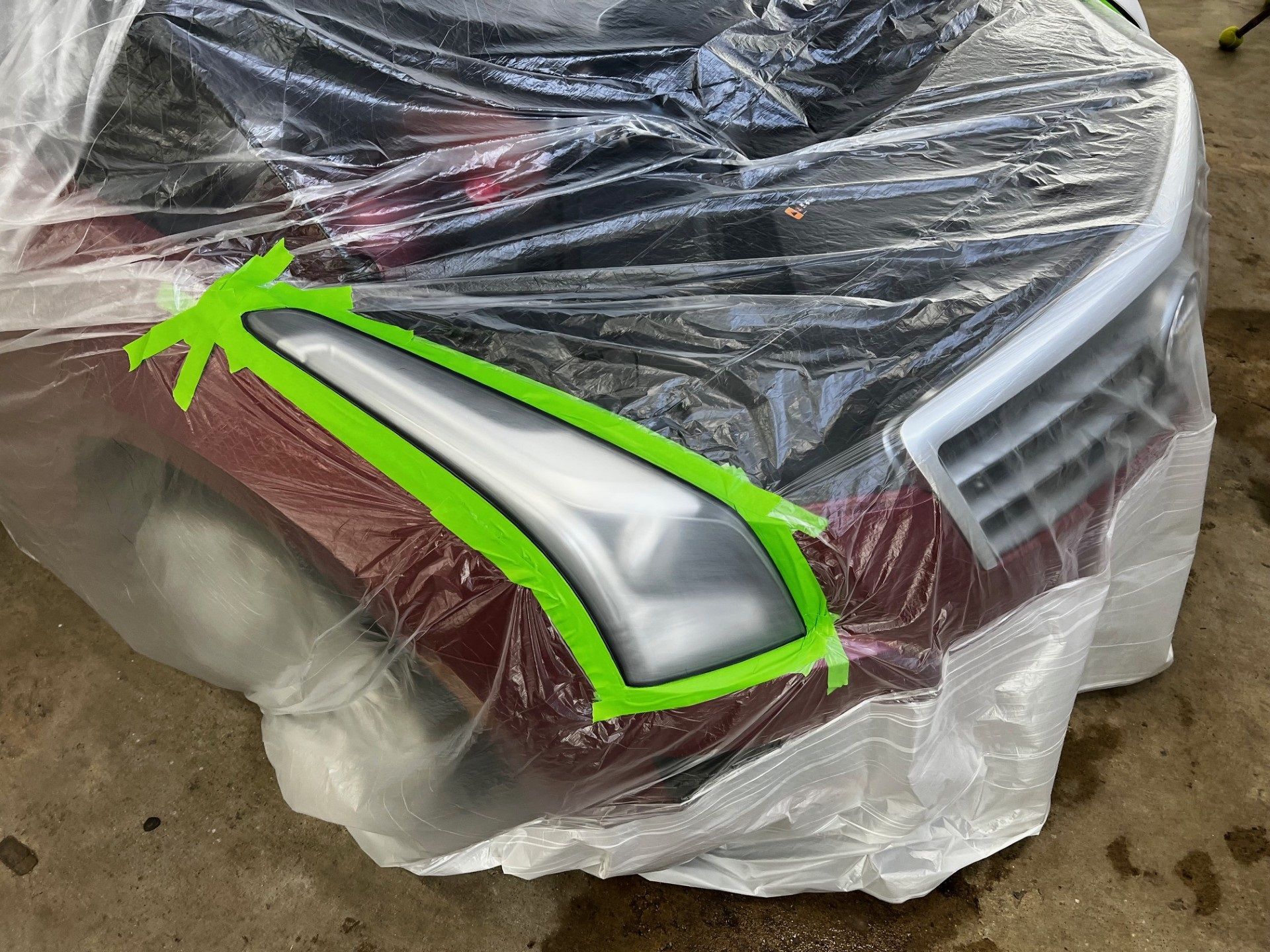 Close-up of sanding and masking headlights for re clear coating