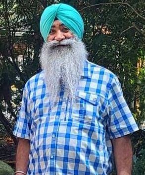 A man with a beard and a turban is wearing a plaid shirt owner of king Restaurant