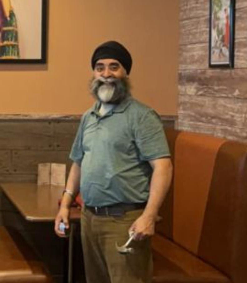 A man with a beard is standing in a restaurant