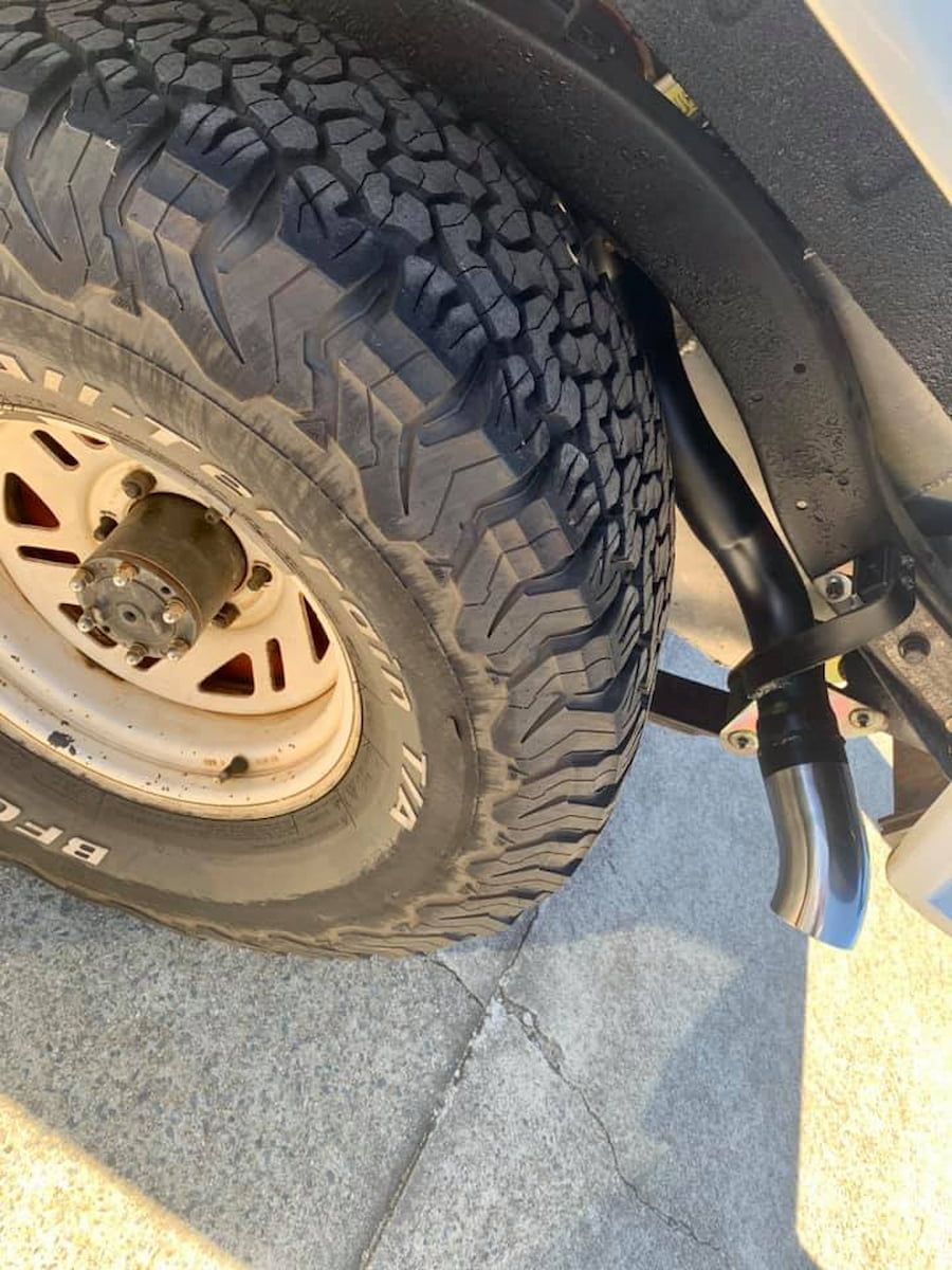 A Close Up Of A Tire On A Car On A Sidewalk — Hannam Street Mufflers and Mechanical In Bungalow, QLD