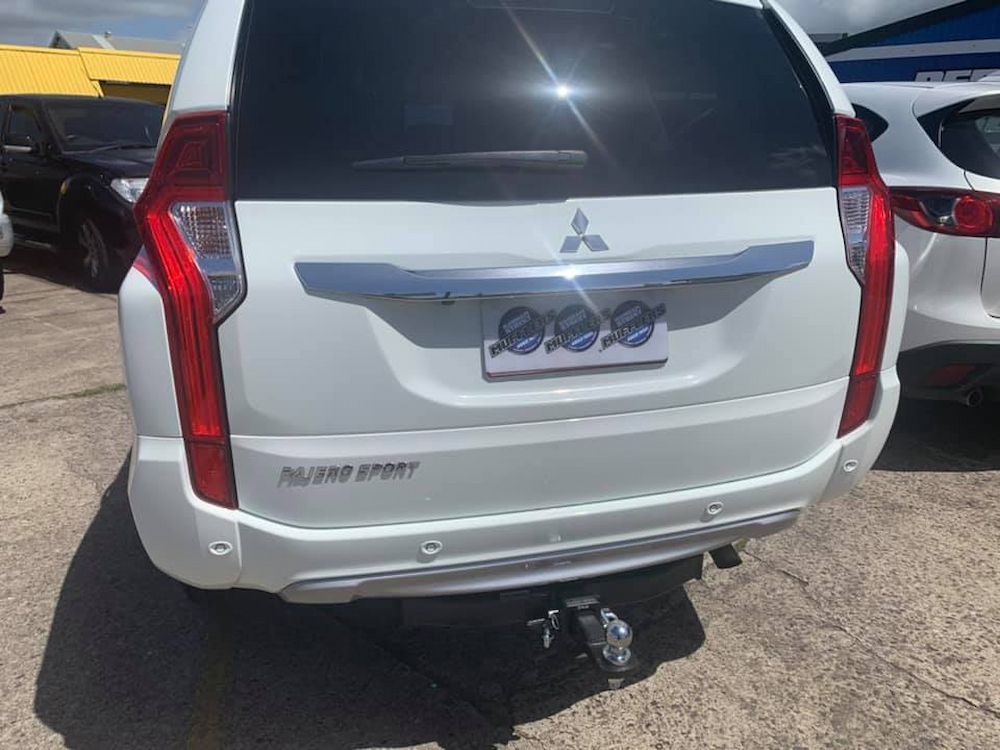 A White Mitsubishi Pajero Sport Is Parked In A Parking Lot — Hannam Street Mufflers and Mechanical In Bungalow, QLD