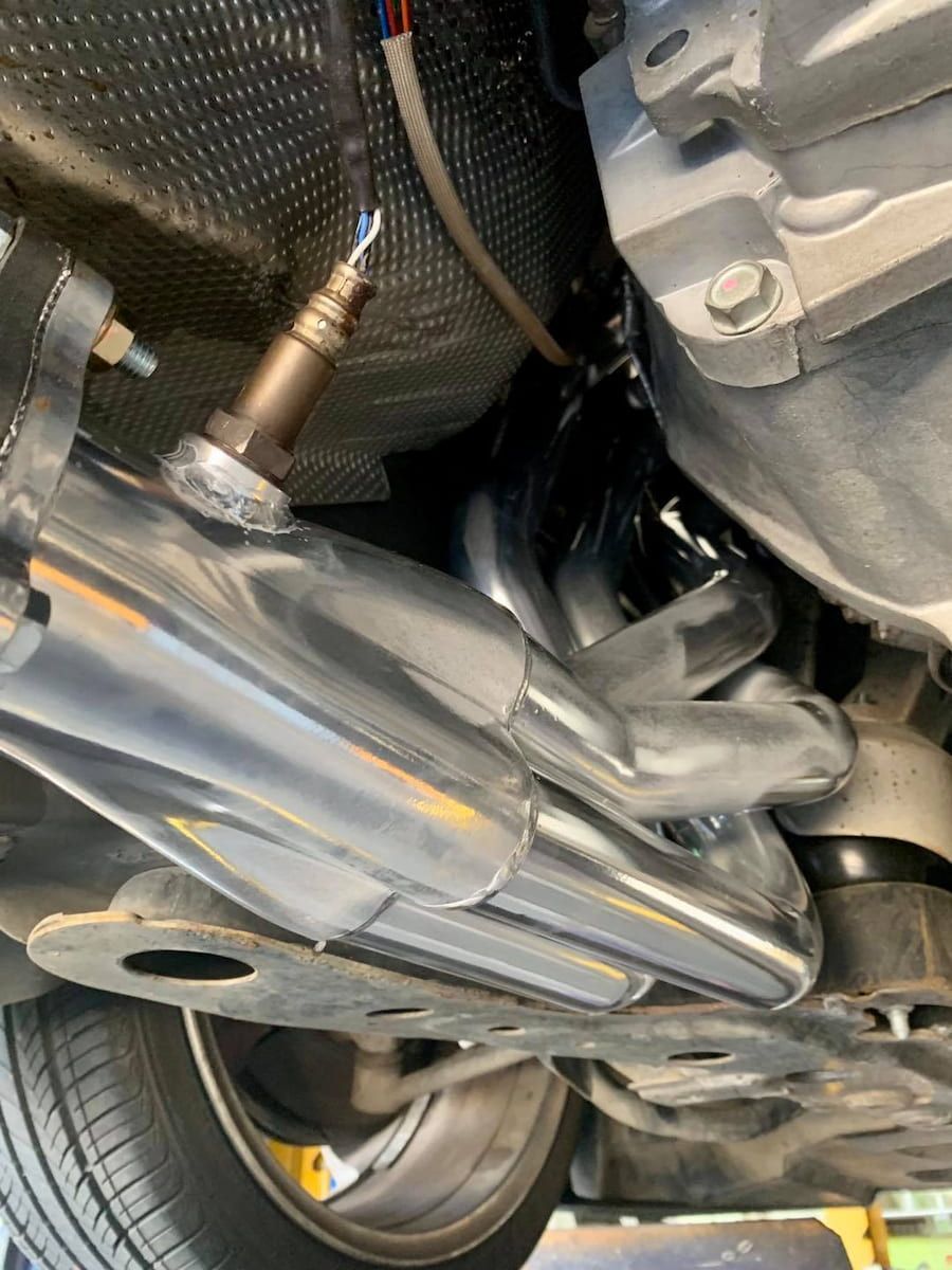 A Detailed View Of The Bottom Of A Car Showcasing The Exhaust Pipe — Hannam Street Mufflers and Mechanical In Bungalow, QLD