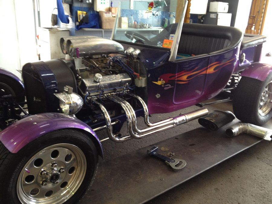 A Purple Car Is Sitting On Top Of A Black Table — Hannam Street Mufflers and Mechanical In Bungalow, QLD