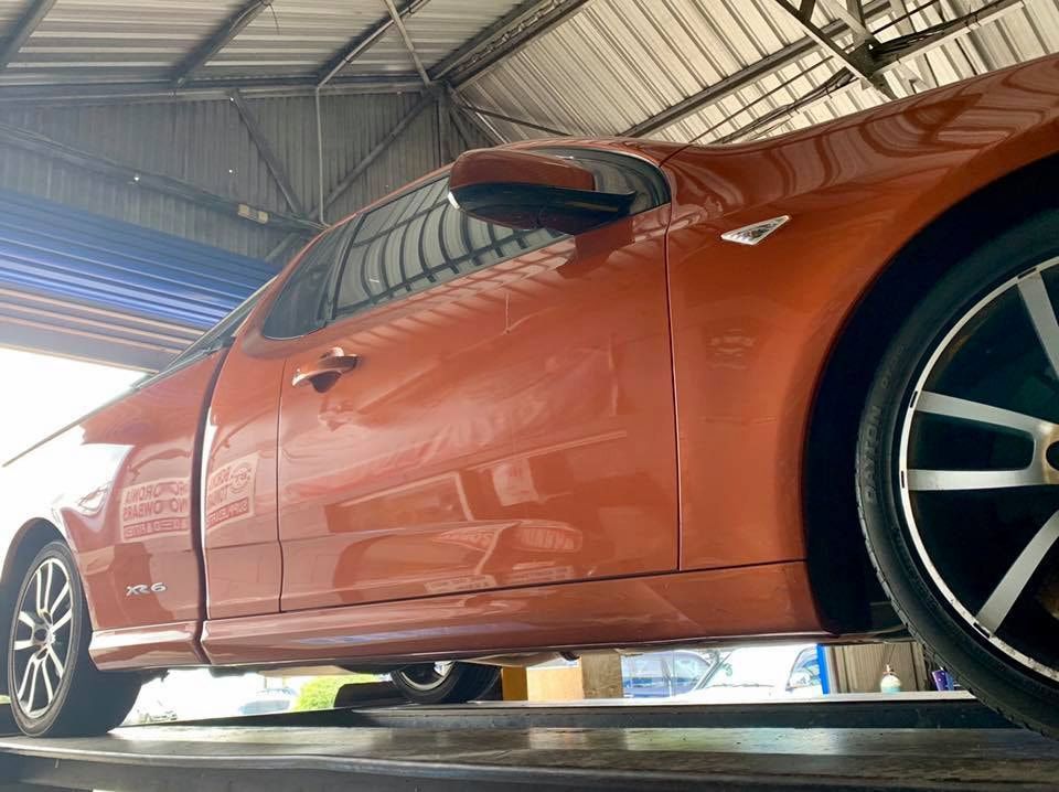 A Car Is Sitting On A Lift In A Garage — Hannam Street Mufflers and Mechanical In Bungalow, QLD