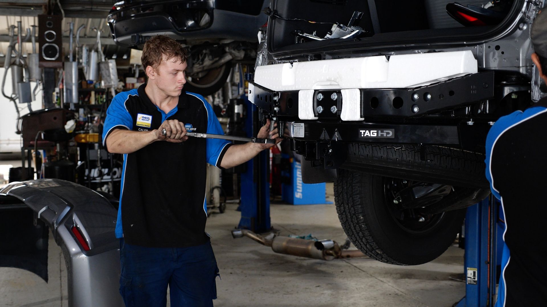 A Mechanic Installing A Tow Bar — Hannam Street Mufflers and Mechanical In Bungalow, QLD