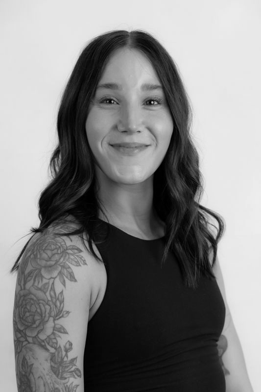 A black and white photo of a woman with a tattoo on her arm
