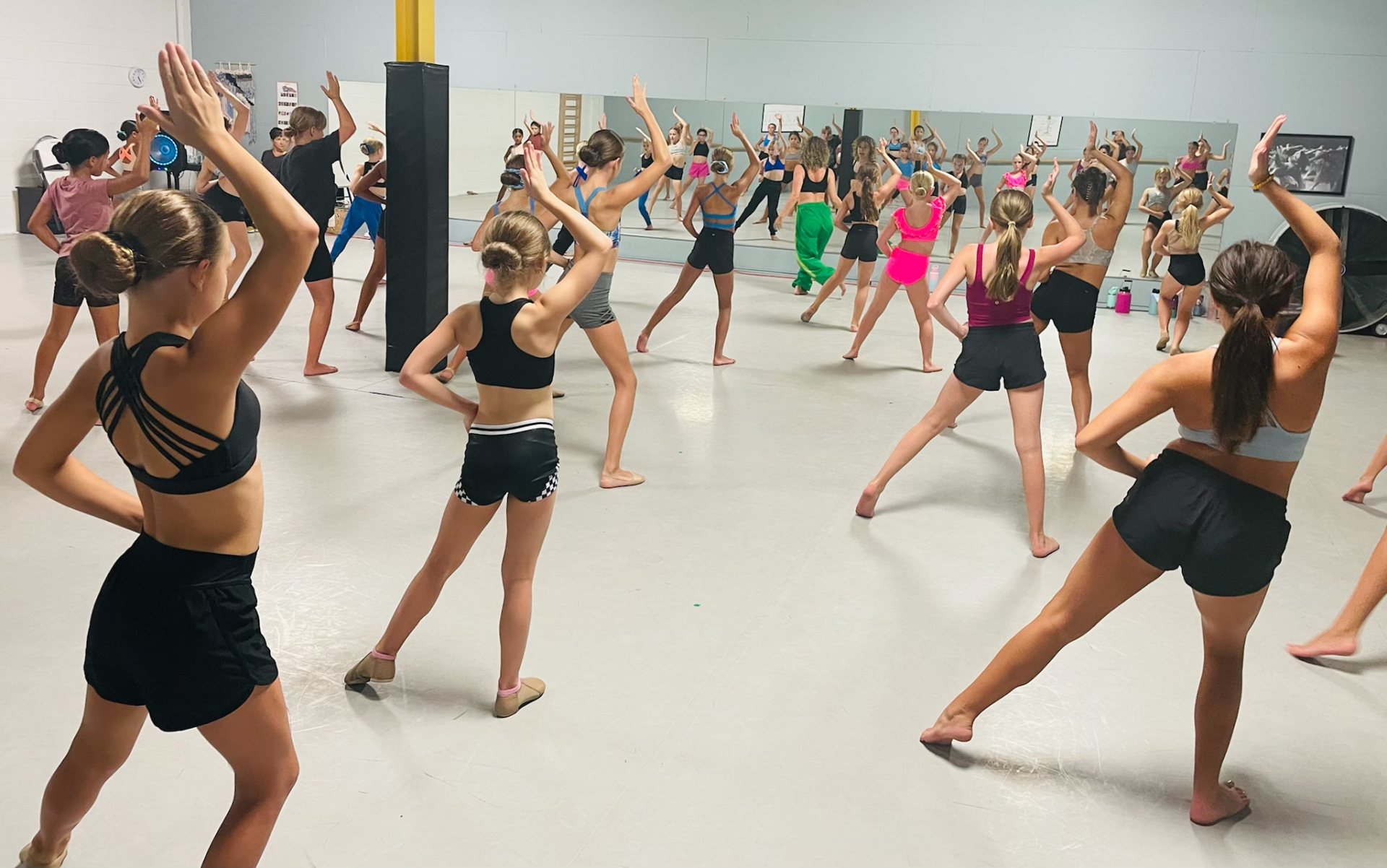 A group of young girls are dancing in a dance studio.