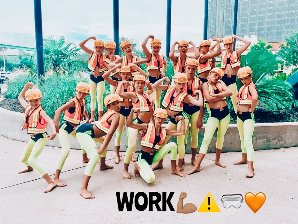 A group of young girls wearing hard hats are posing for a picture.