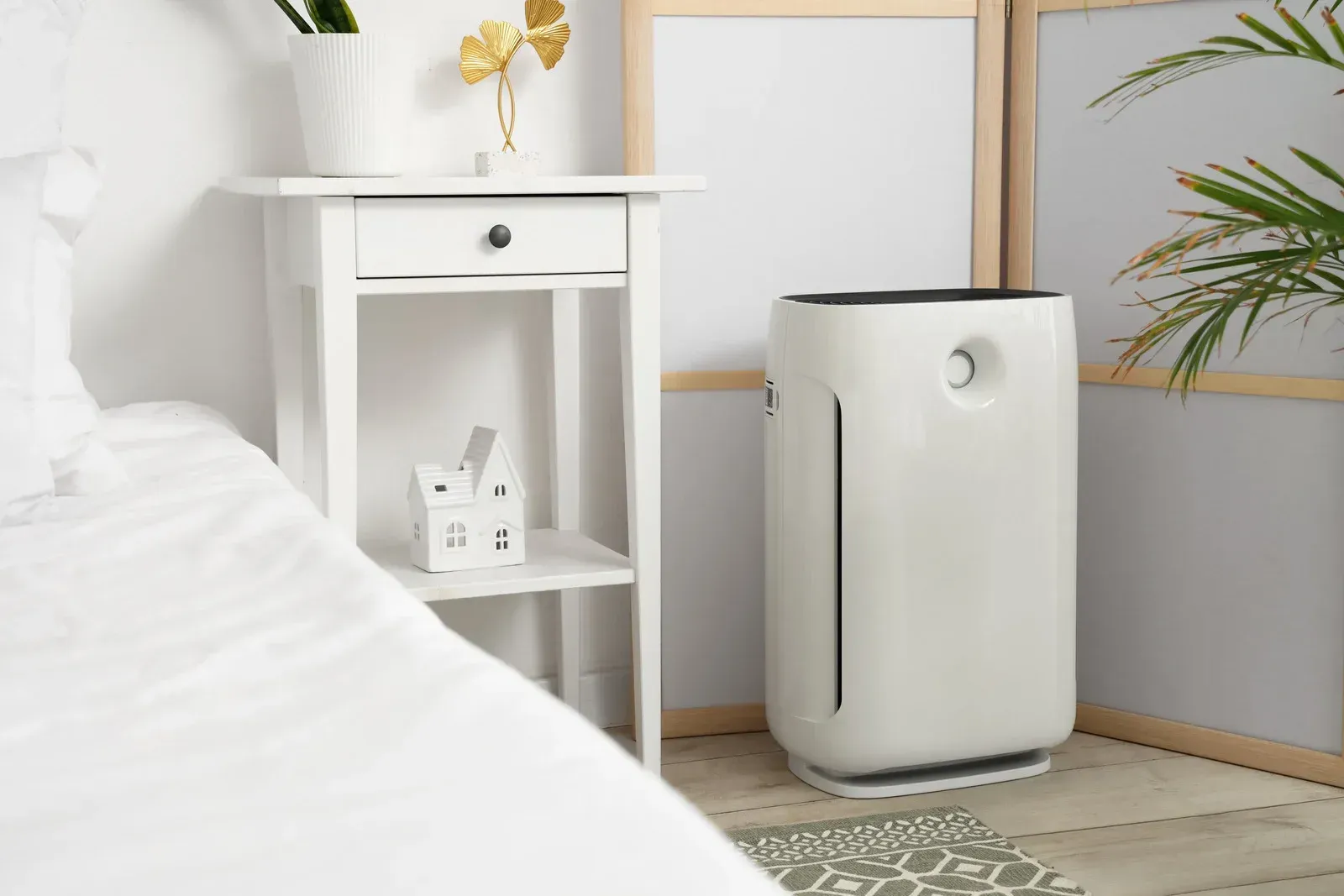 A hand holds a thermal imaging camera in a wood-paneled room, showing a heat signature directed toward a chandelier.
