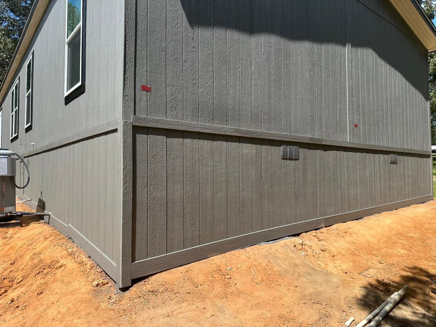 Gray accent wall with molding, a black floating shelf, and sconces. Wires hang below.