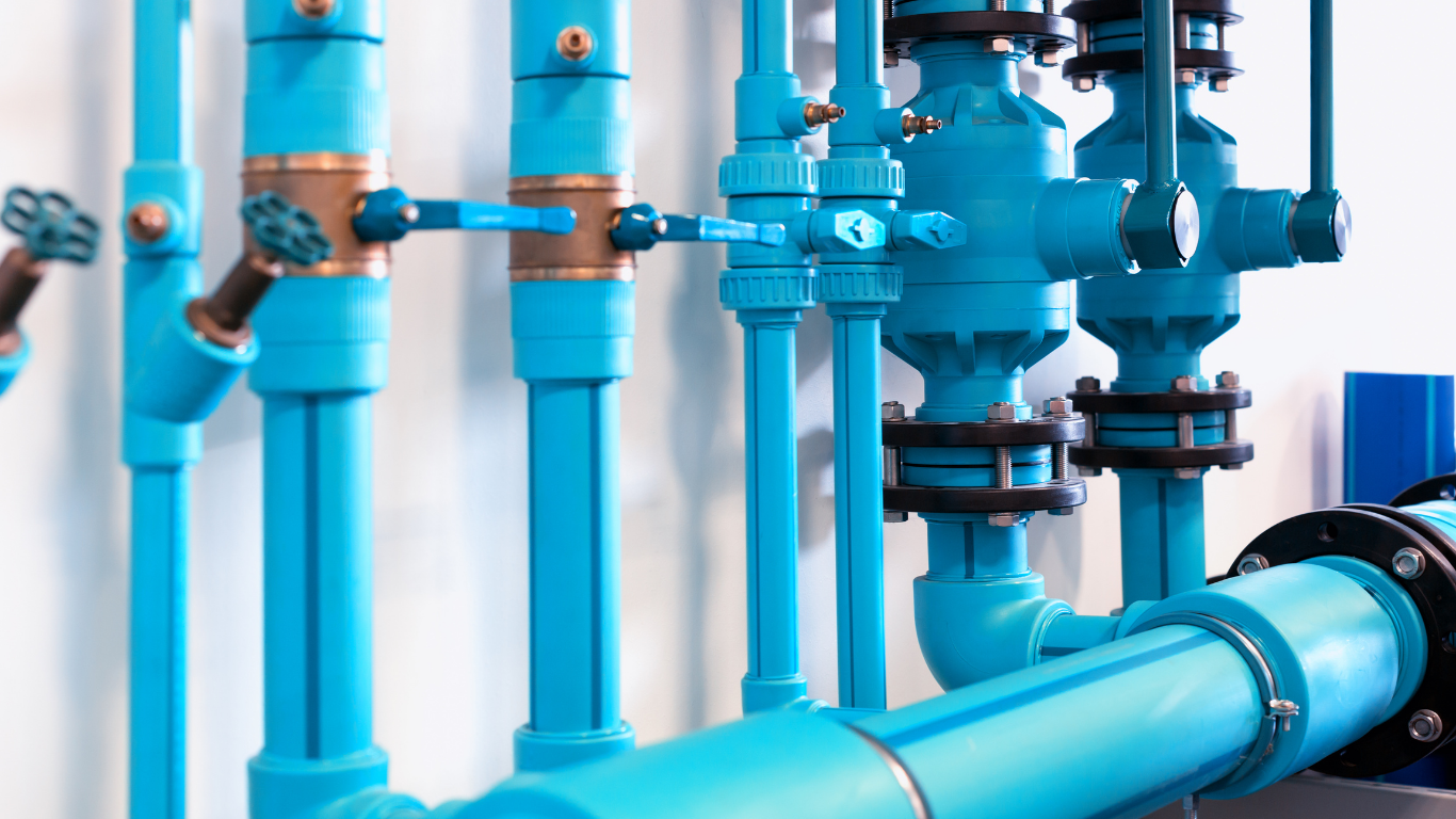 Blue pipes and valves in an industrial setting, likely for water or chemical transport.