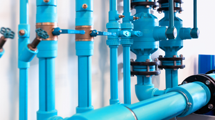 Blue pipes and valves in an industrial setting.