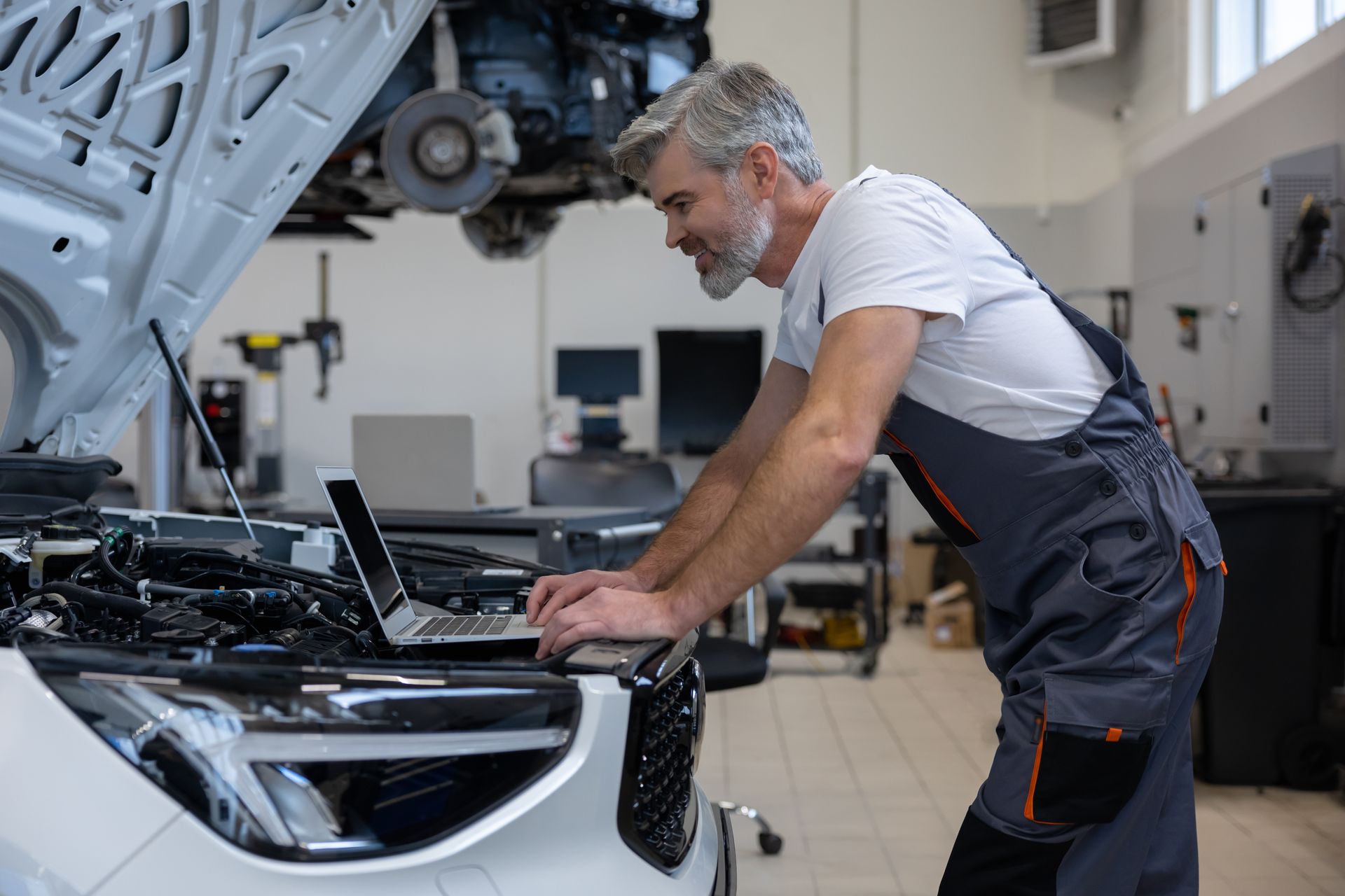 Man in safety gear using a grinder, creating sparks in a workshop.