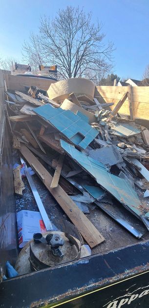 A pile of wood and metal is sitting in a dumpster.
