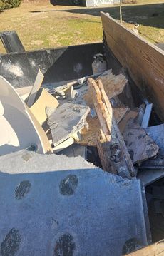 A pile of junk is sitting in a dumpster.