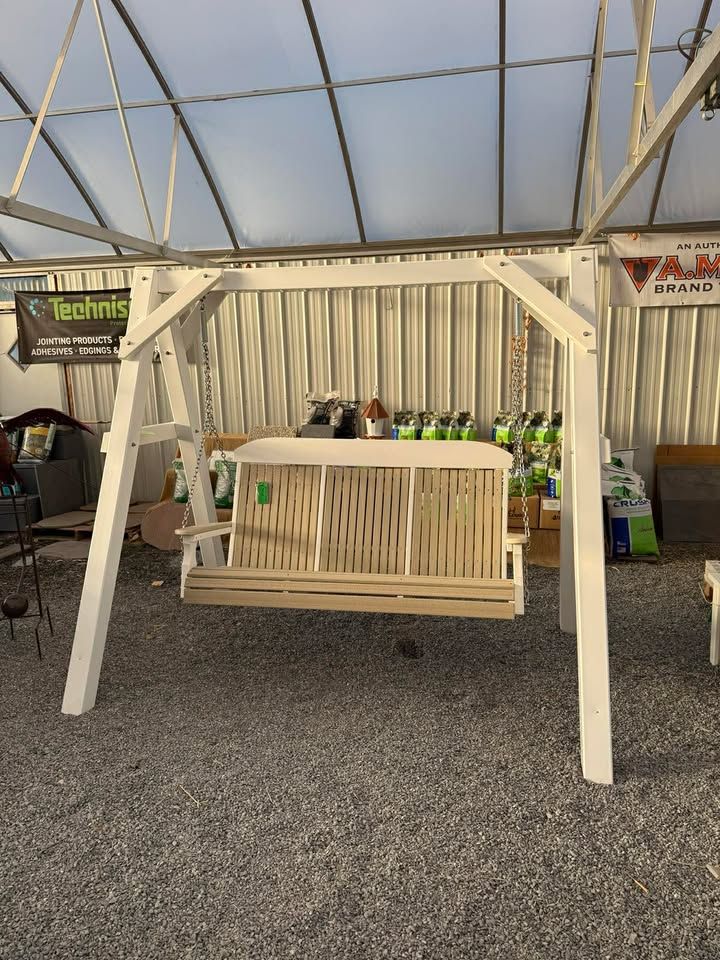 Wooden swing bench display in a tented outdoor market booth with bottled drinks behind it