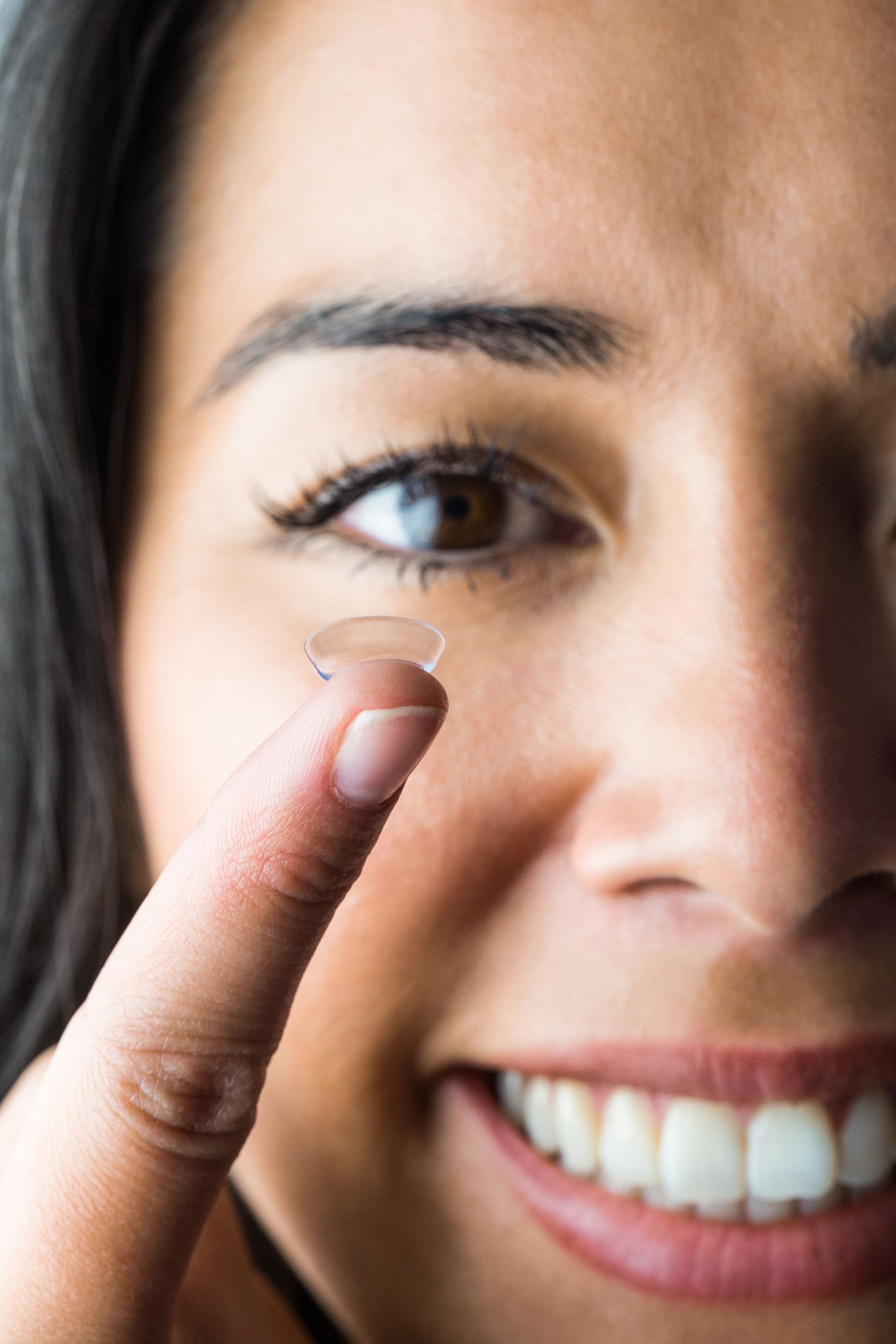 woman holding contact lense
