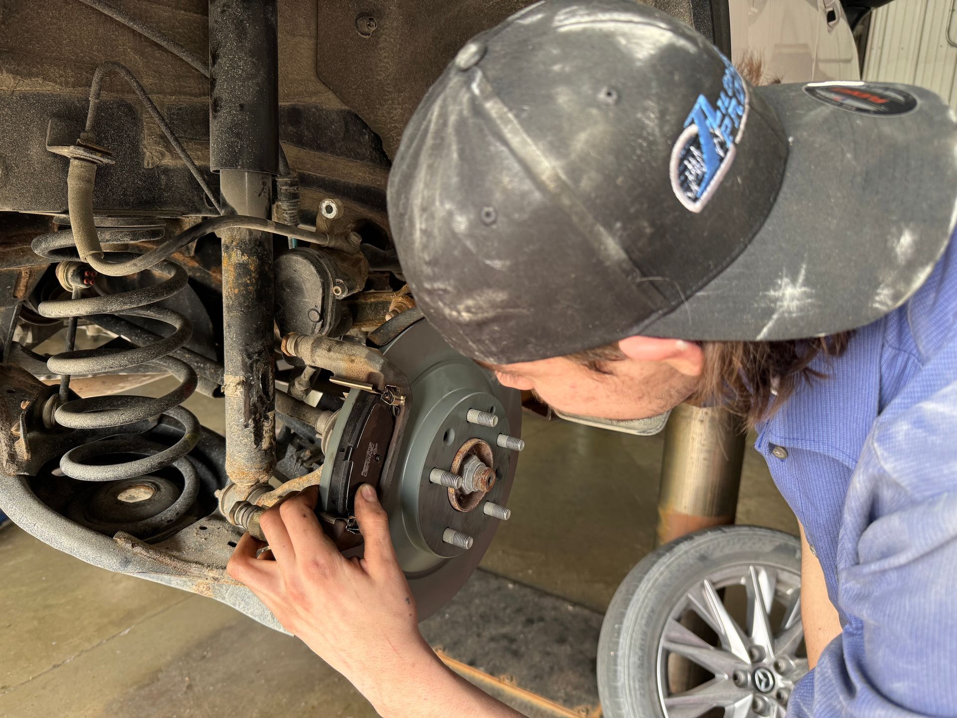 A man wearing a hat is working on a car