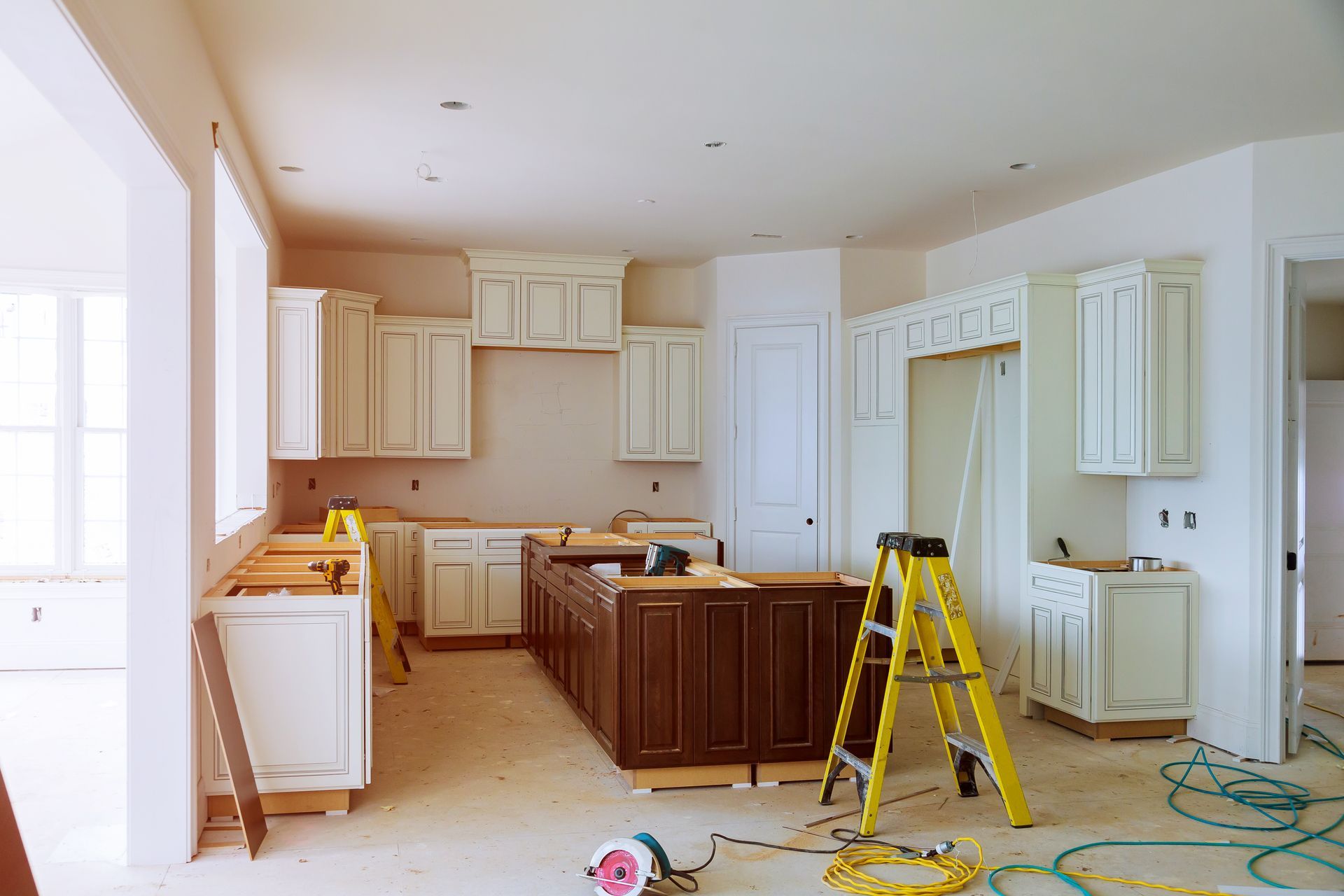 A kitchen under construction with a yellow ladder on the floor.