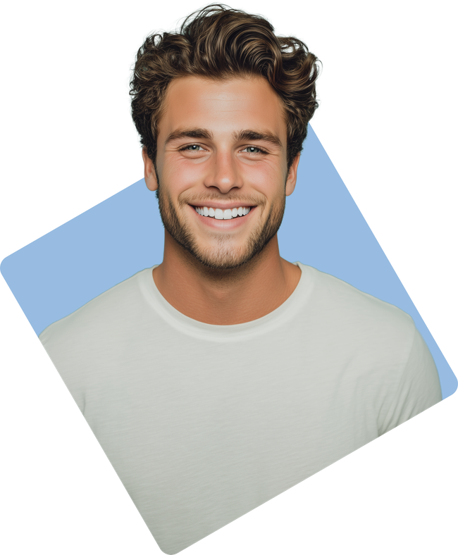 Smiling young man with curly brown hair, wearing a white t-shirt, set against a light blue backdrop.