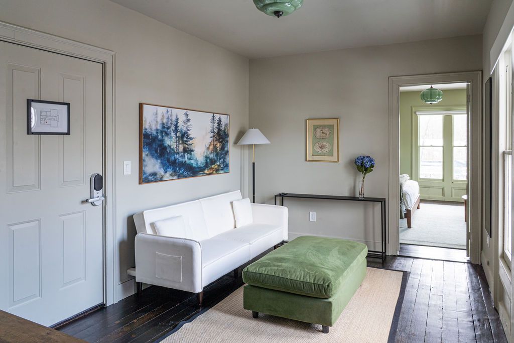 Bedroom with a king bed, purple accents, and a large window.