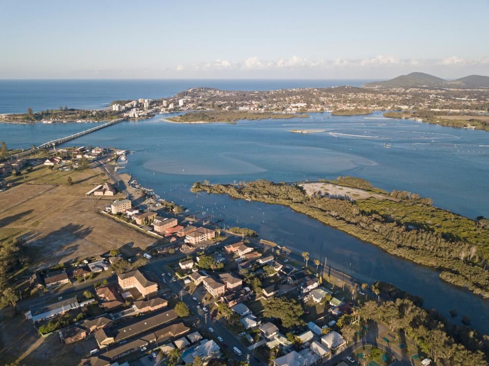 An Aerial View of A Body of Water Surrounded by Houses and Trees — Podium Solar in Forster, NSW