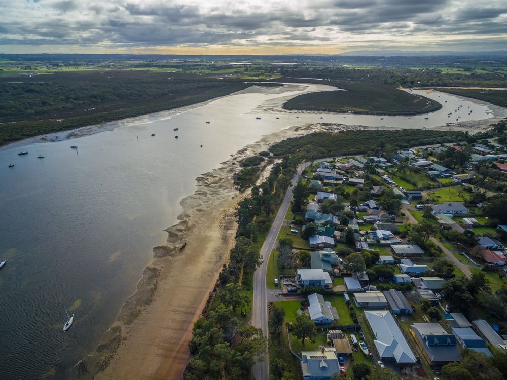 An Aerial View of A River Surrounded by Houses and Trees — Podium Solar in Rutherford, NSW