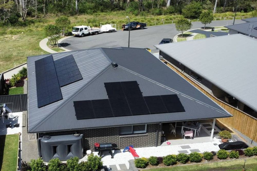 A Man Is Installing Solar Panels on A Roof — Podium Solar in Cameron Park, NSW