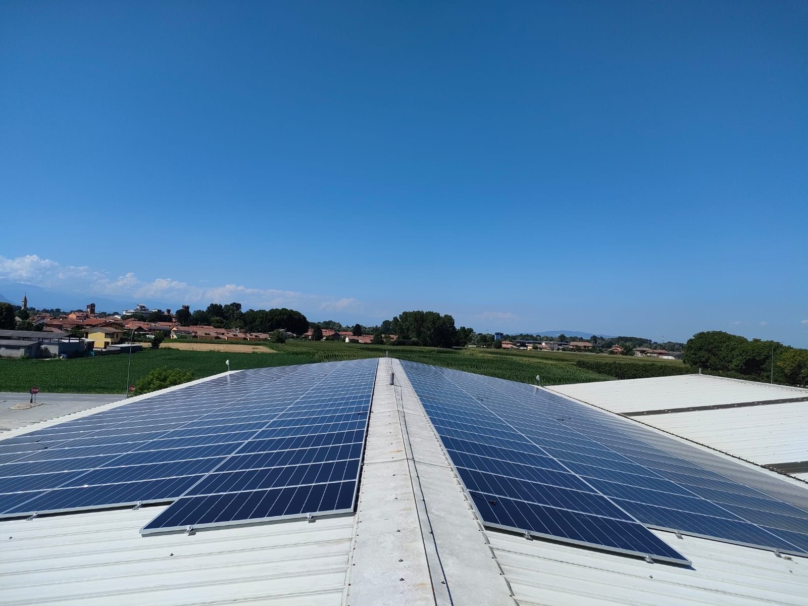Tetto con molti pannelli fotovoltaici e panorama sullo sfondo