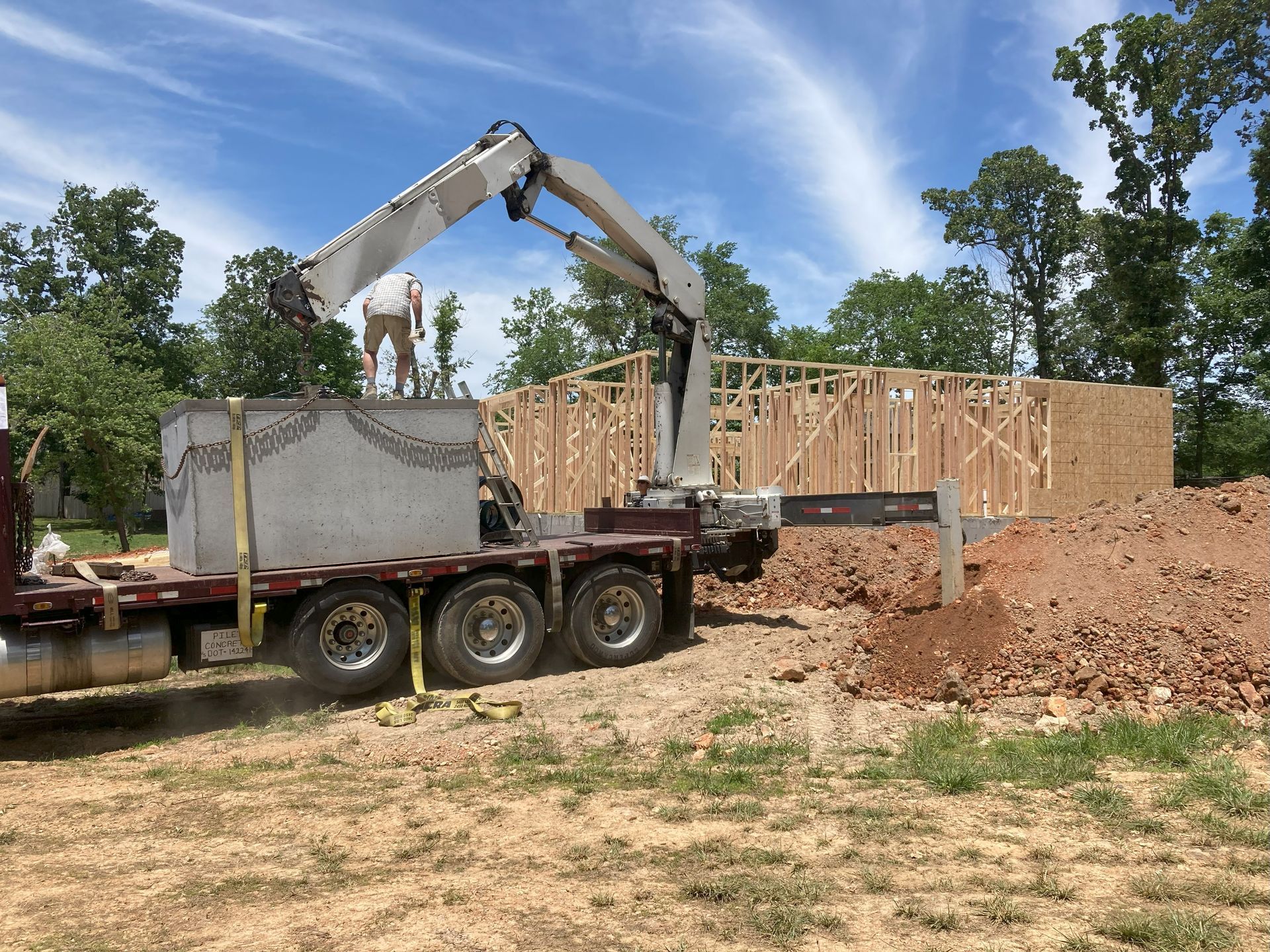 A truck is carrying a large concrete block on a construction site.