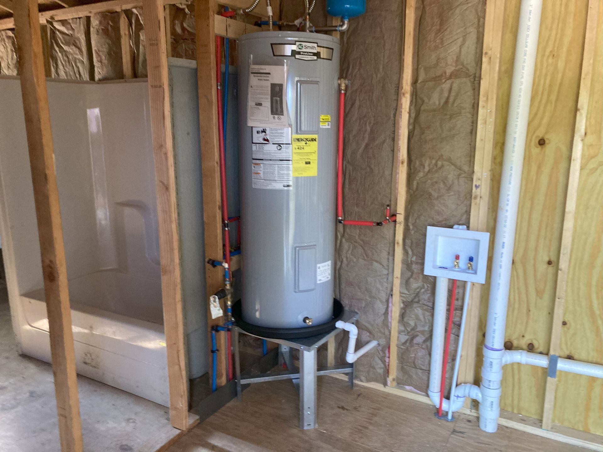 A water heater is sitting in a room under construction.