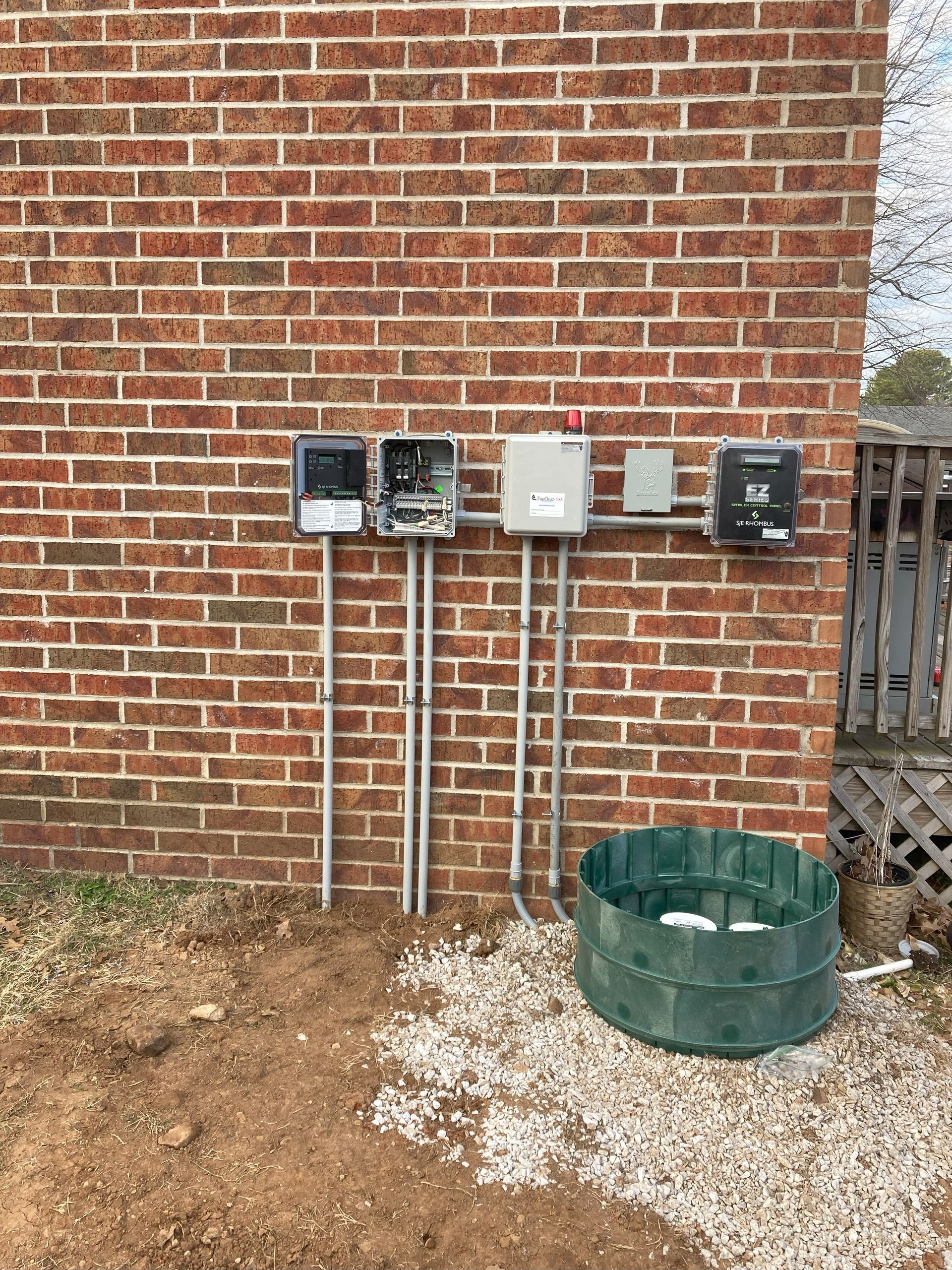 A brick wall with a bunch of electrical boxes on it.