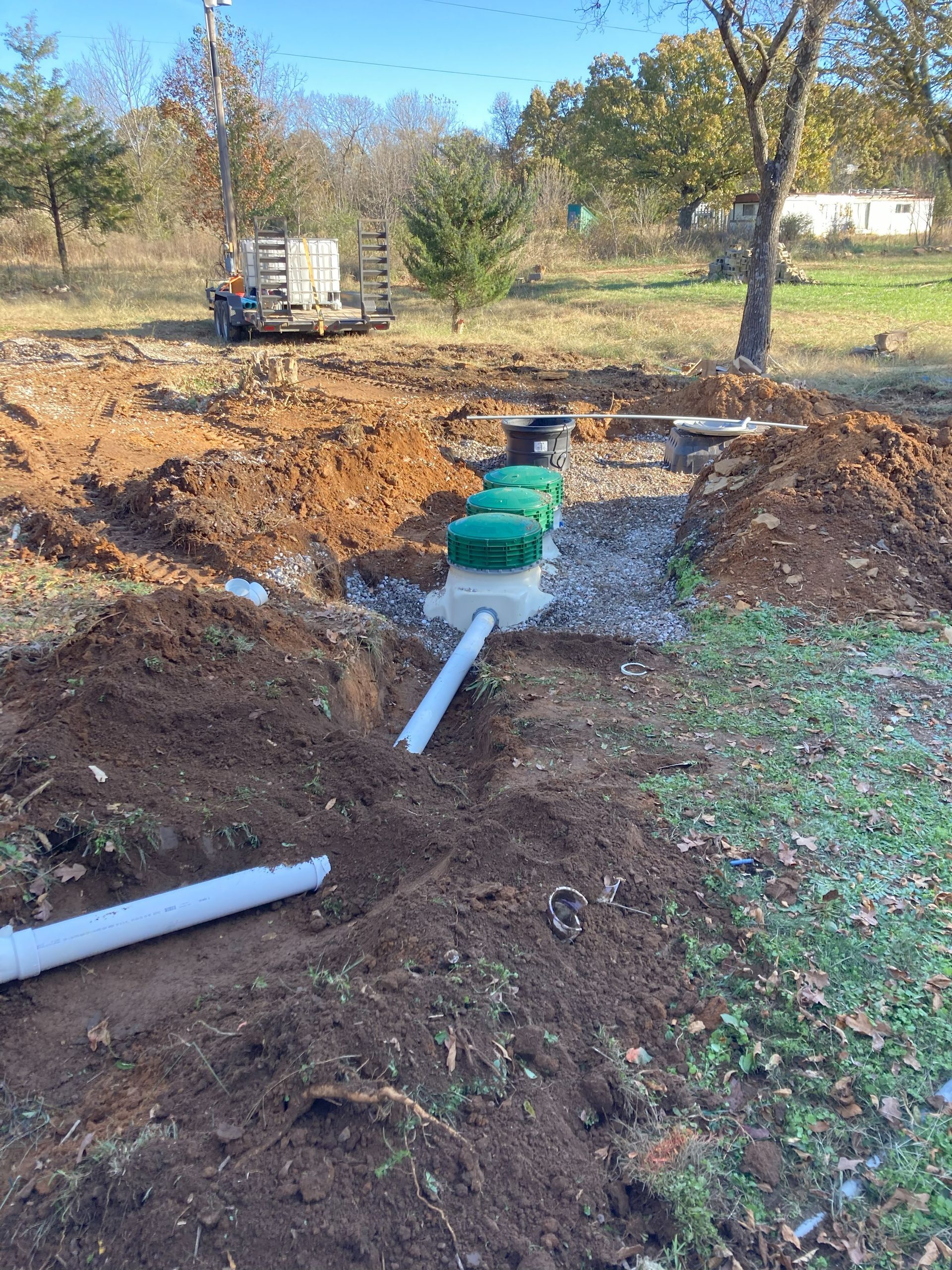 A septic tank is being installed in a dirt field.