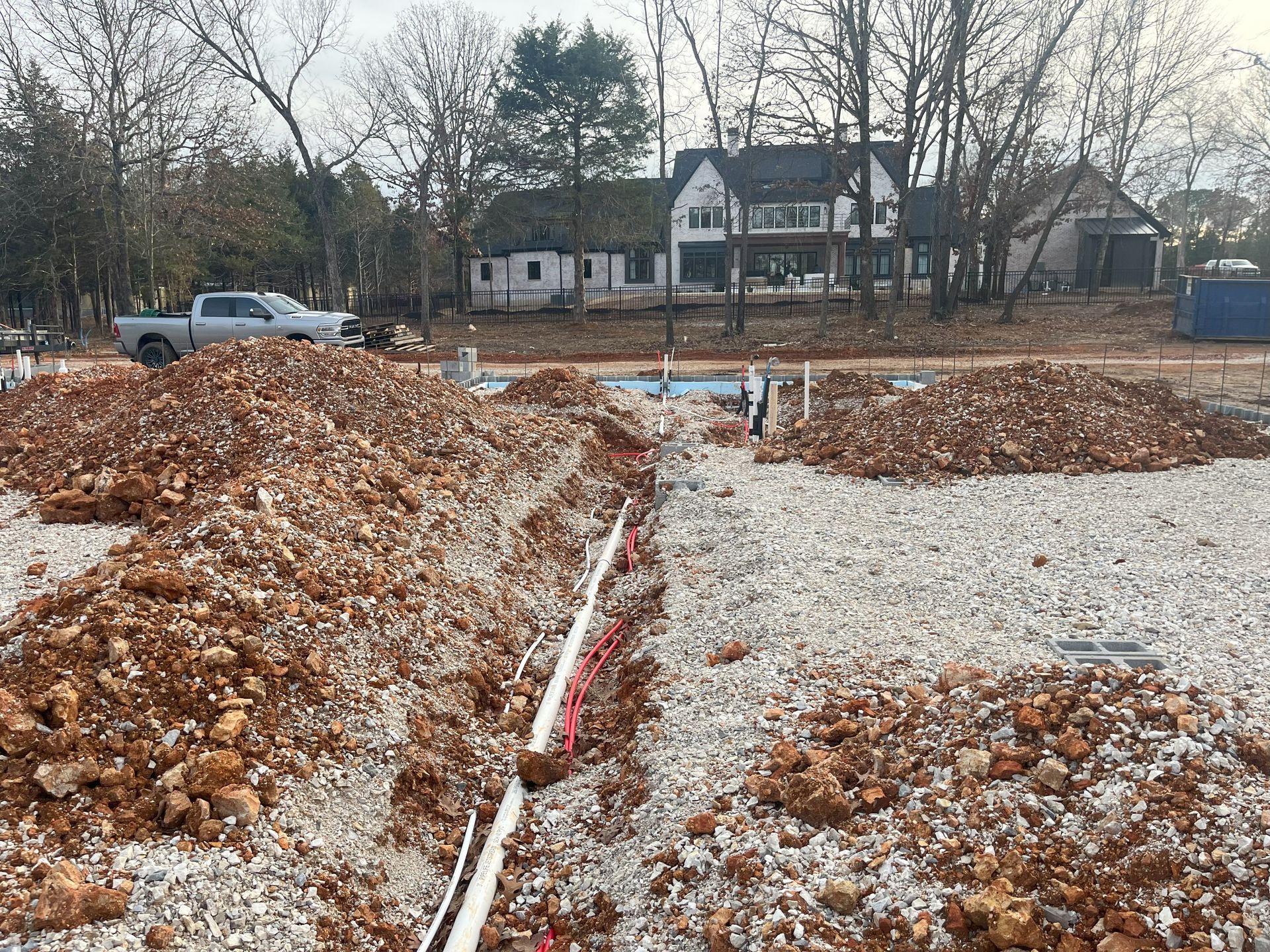 A large pile of dirt is sitting in front of a house under construction.