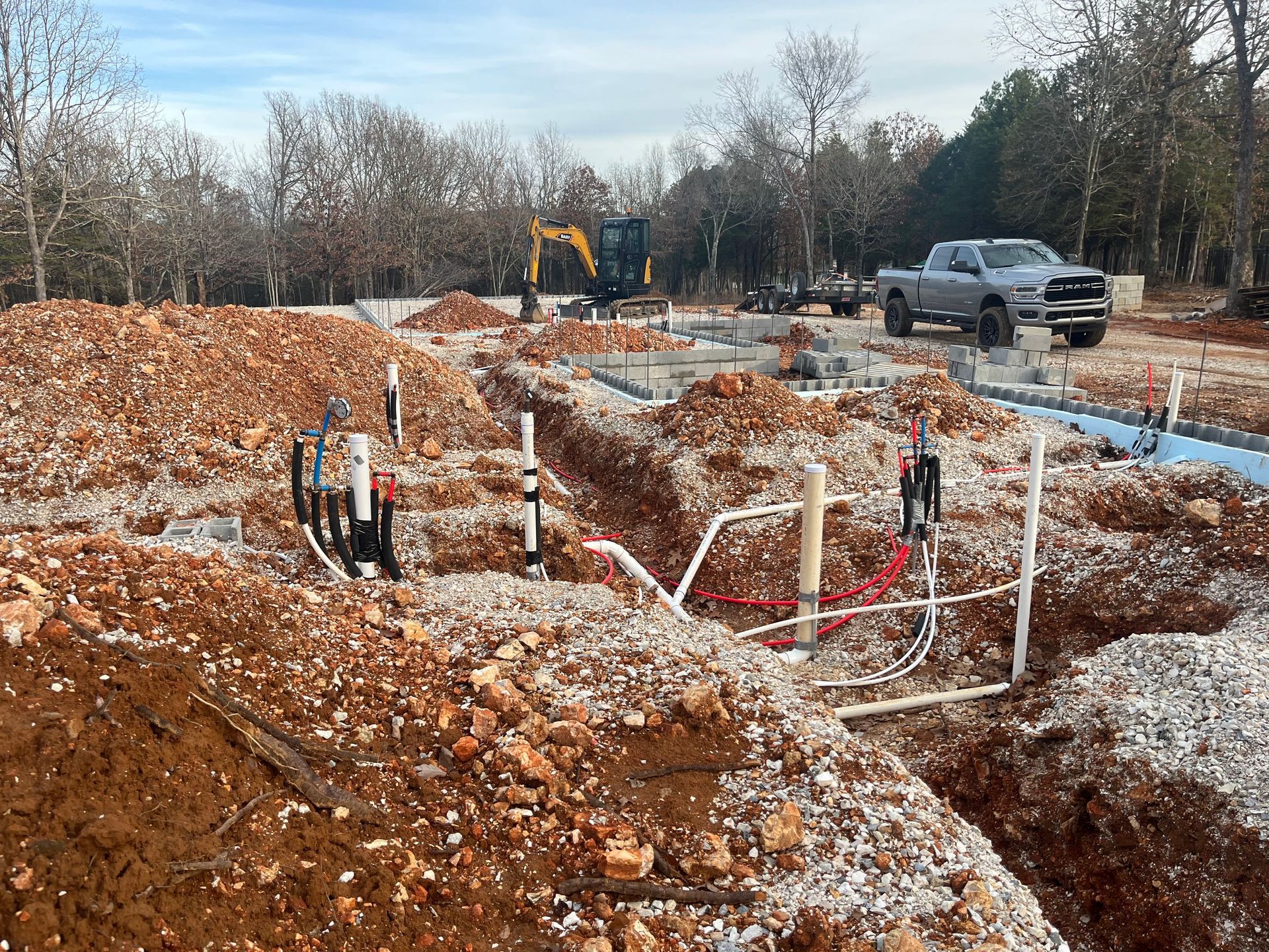 A construction site with a truck parked in the dirt.