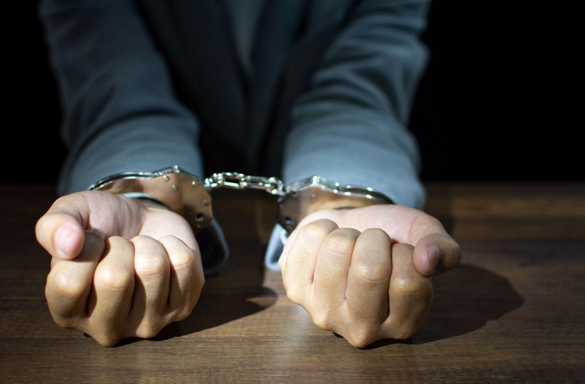 A man in handcuffs is sitting at a table.