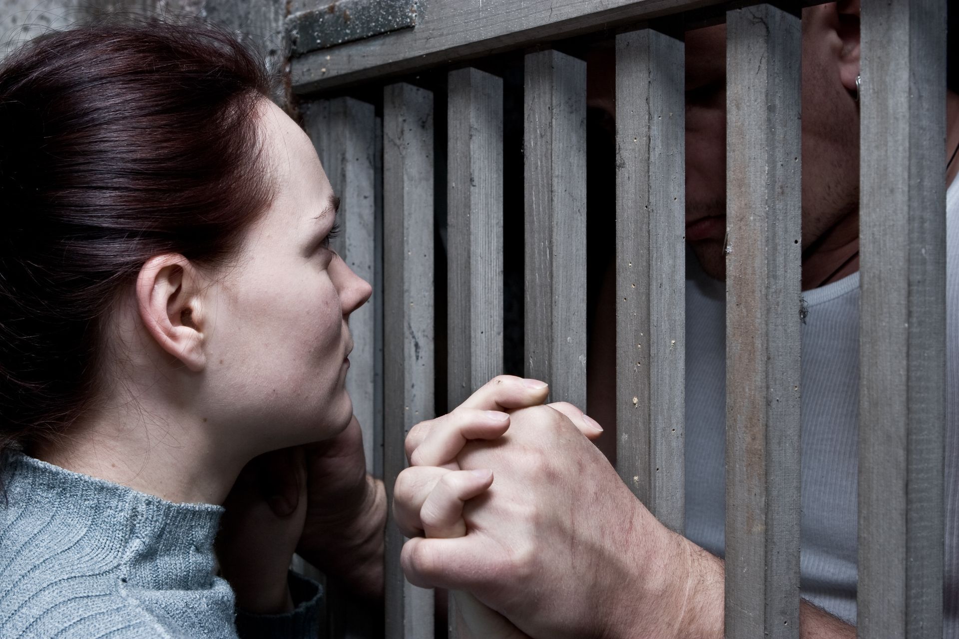 Lovers Holding Hands Between Prison Cells – Land O' Lakes, FL – Brad's Bail Bonds